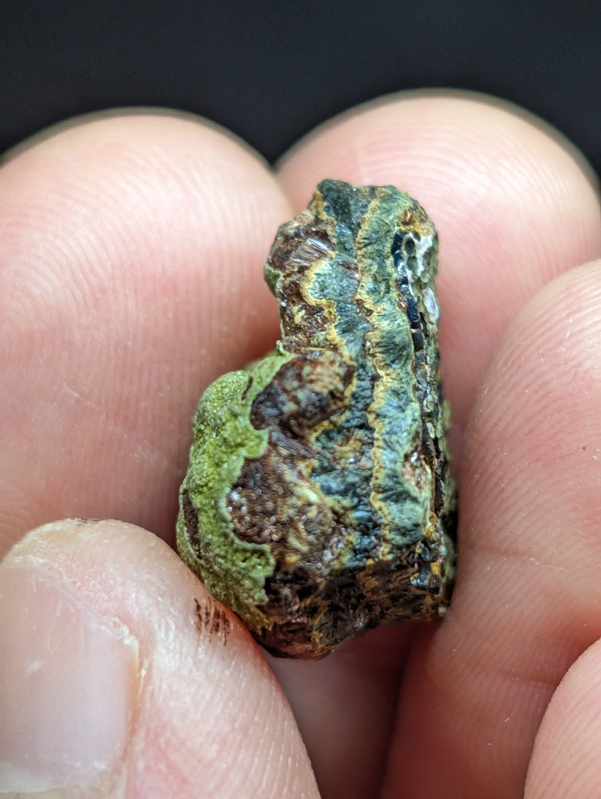 A rough, irregularly shaped mineral specimen with a mottled green and brown surface.