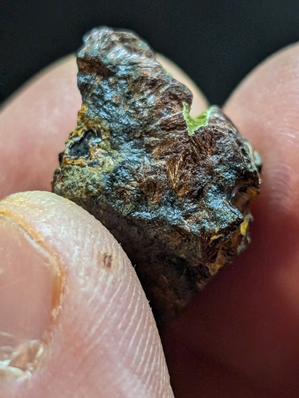 A rough, irregularly shaped mineral specimen with a mottled surface of dark brown and bluish-green patina.