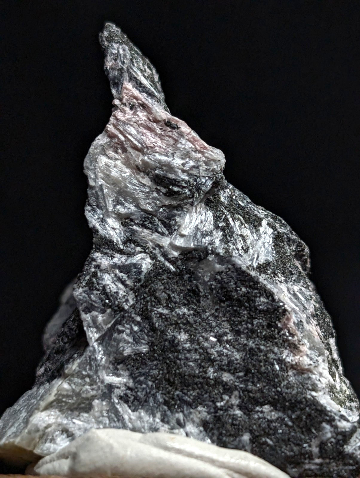 A rugged, naturally formed mineral specimen with a striking mix of translucent silver and dark black crystalline textures.