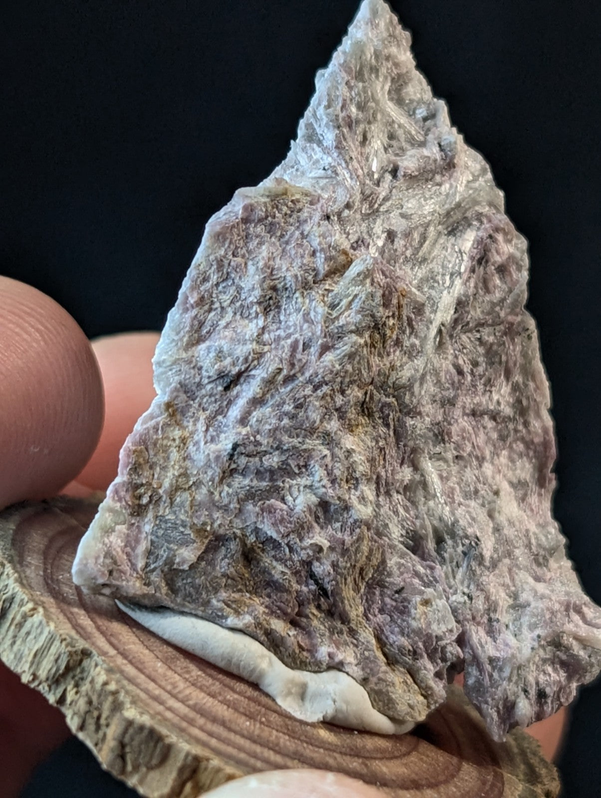 A rugged, triangular-shaped stone arrowhead with a mottled gray and white surface texture.