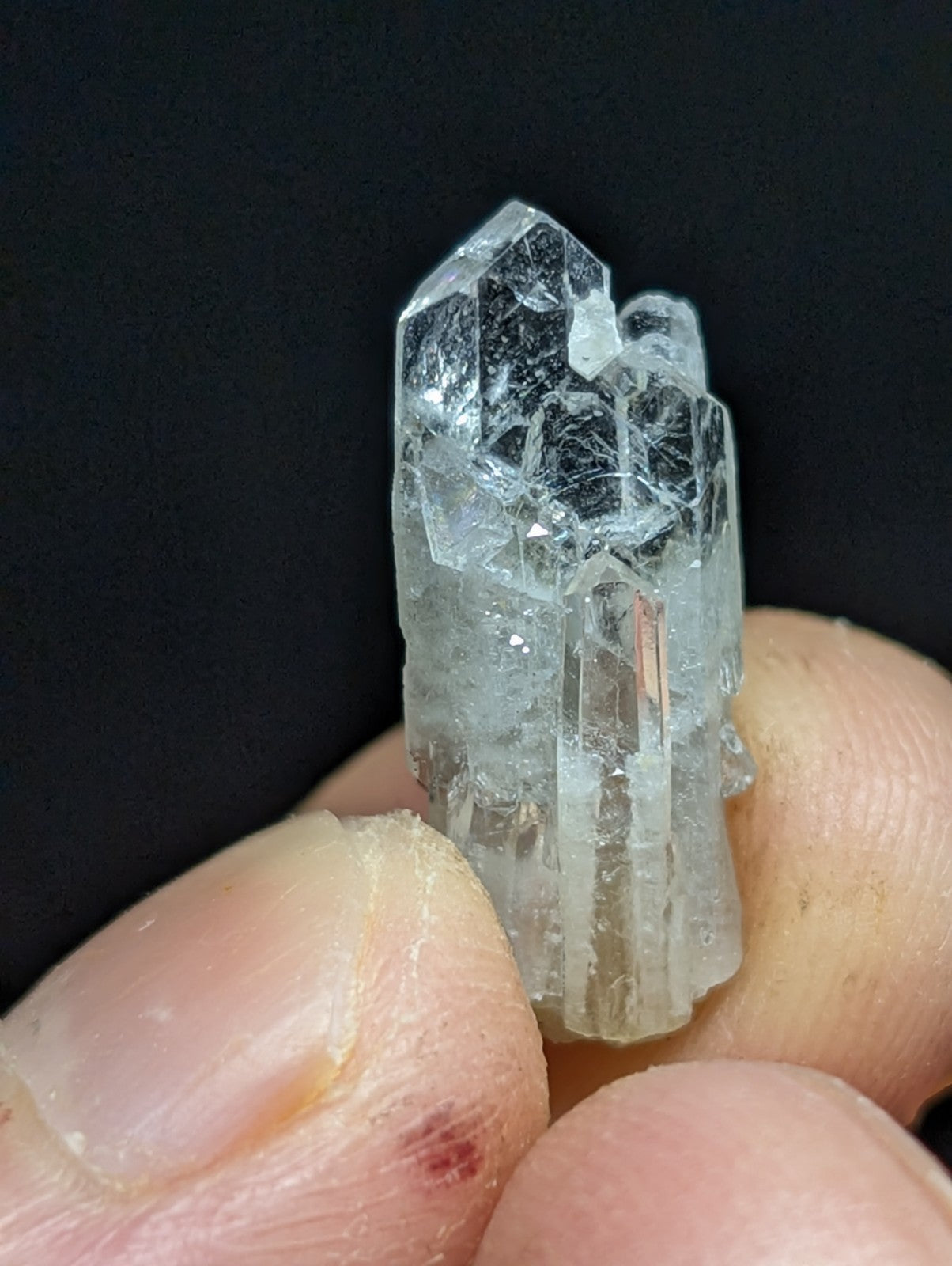 A translucent, clear quartz crystal cluster with sharp facets and internal inclusions.