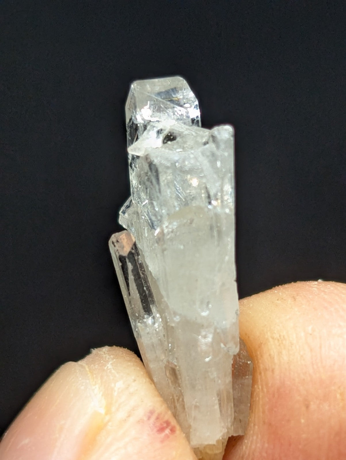 A clear, translucent quartz crystal cluster with sharp facets and a slightly cloudy base.