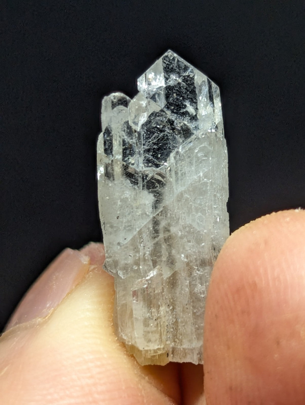 A translucent, clear quartz crystal cluster with a faceted, geometric structure and visible internal inclusions.