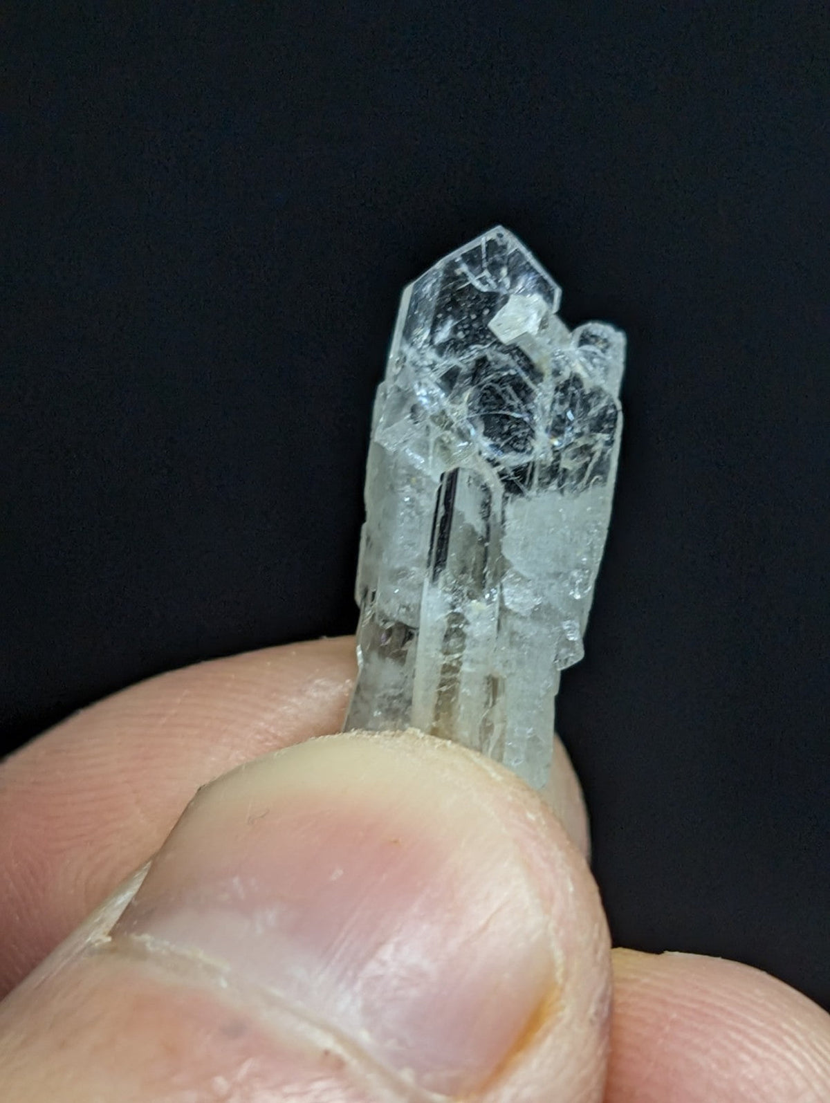 A clear, translucent quartz crystal with a pointed tip and visible internal inclusions.