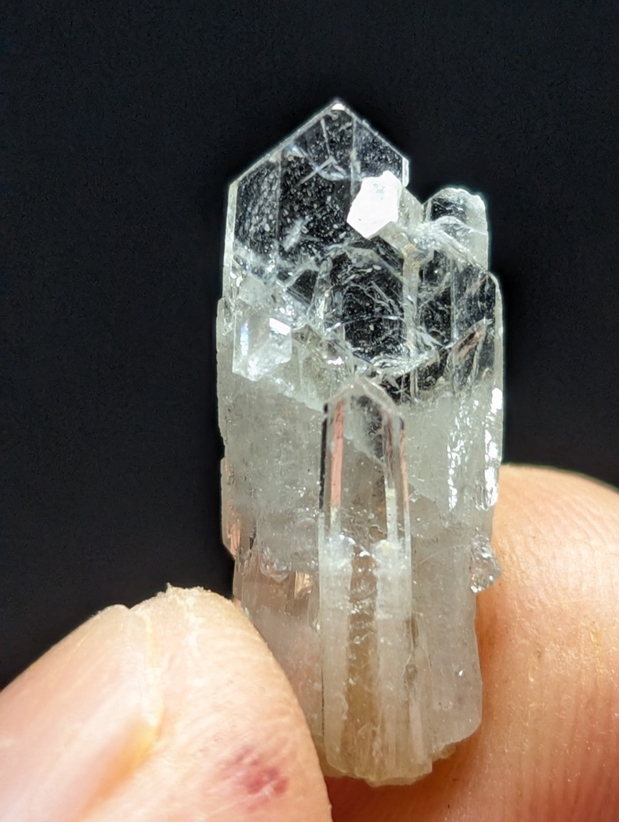 A translucent, clear quartz crystal cluster with sharp geometric facets and a slightly cloudy base.