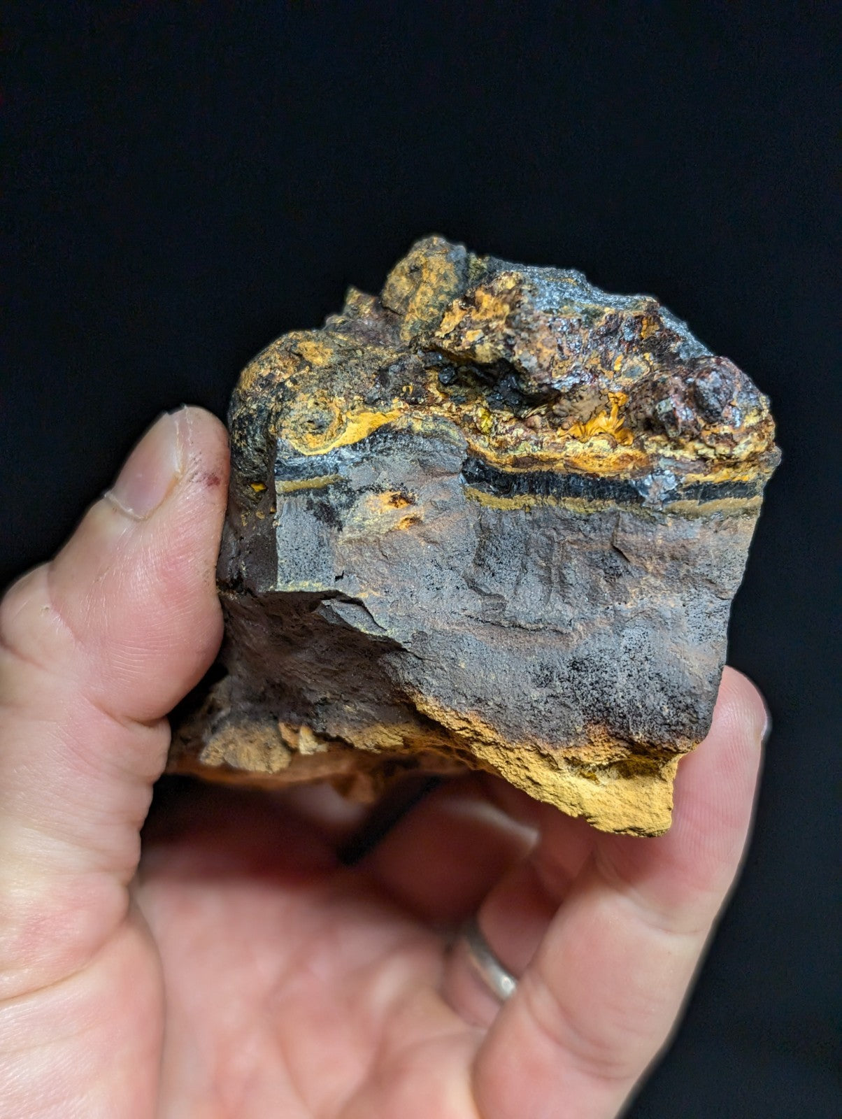 A rugged, irregularly shaped mineral specimen with striking yellow and black striations.