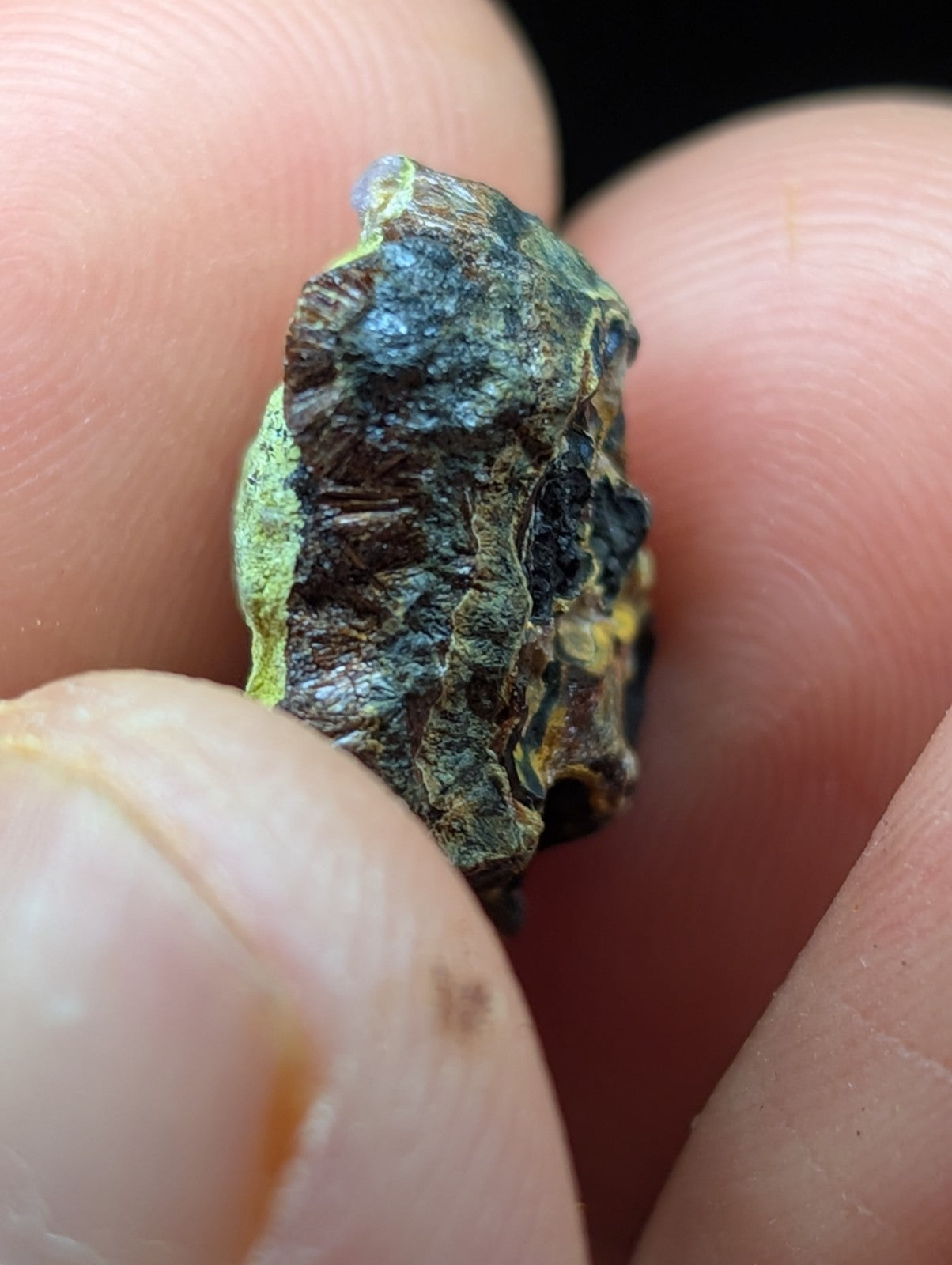 A rugged, irregularly shaped mineral specimen with a mottled surface of greenish-blue patina and dark brown to black patches.