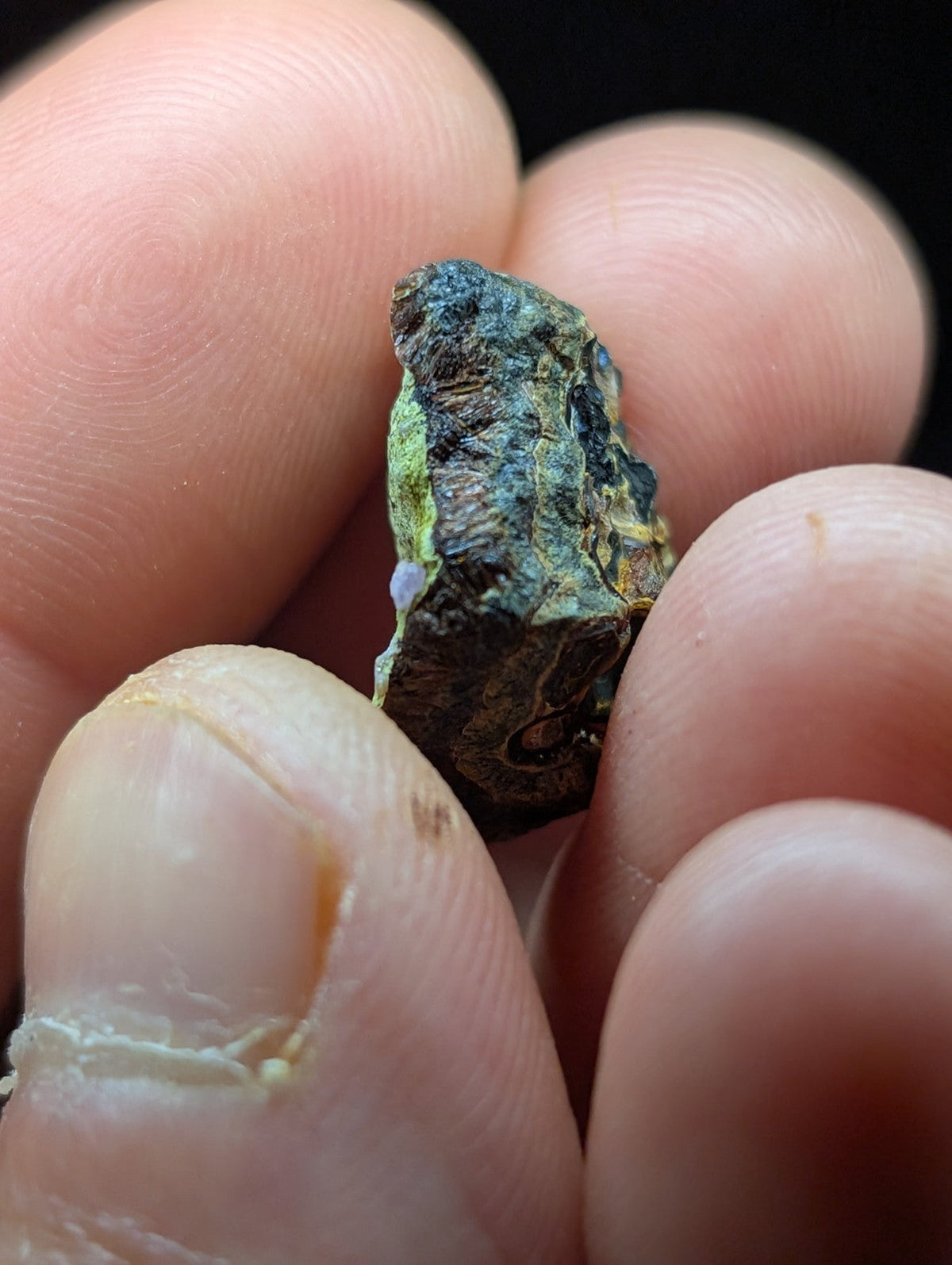 A rough, irregularly shaped mineral specimen with a mottled green and dark blue patina.