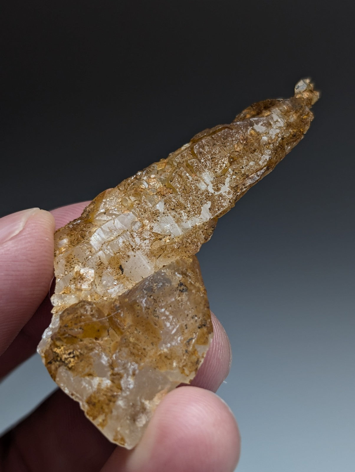 A rare and unique translucent amber quartz crystal with golden brown inclusions and jagged surface from Arkansas USA