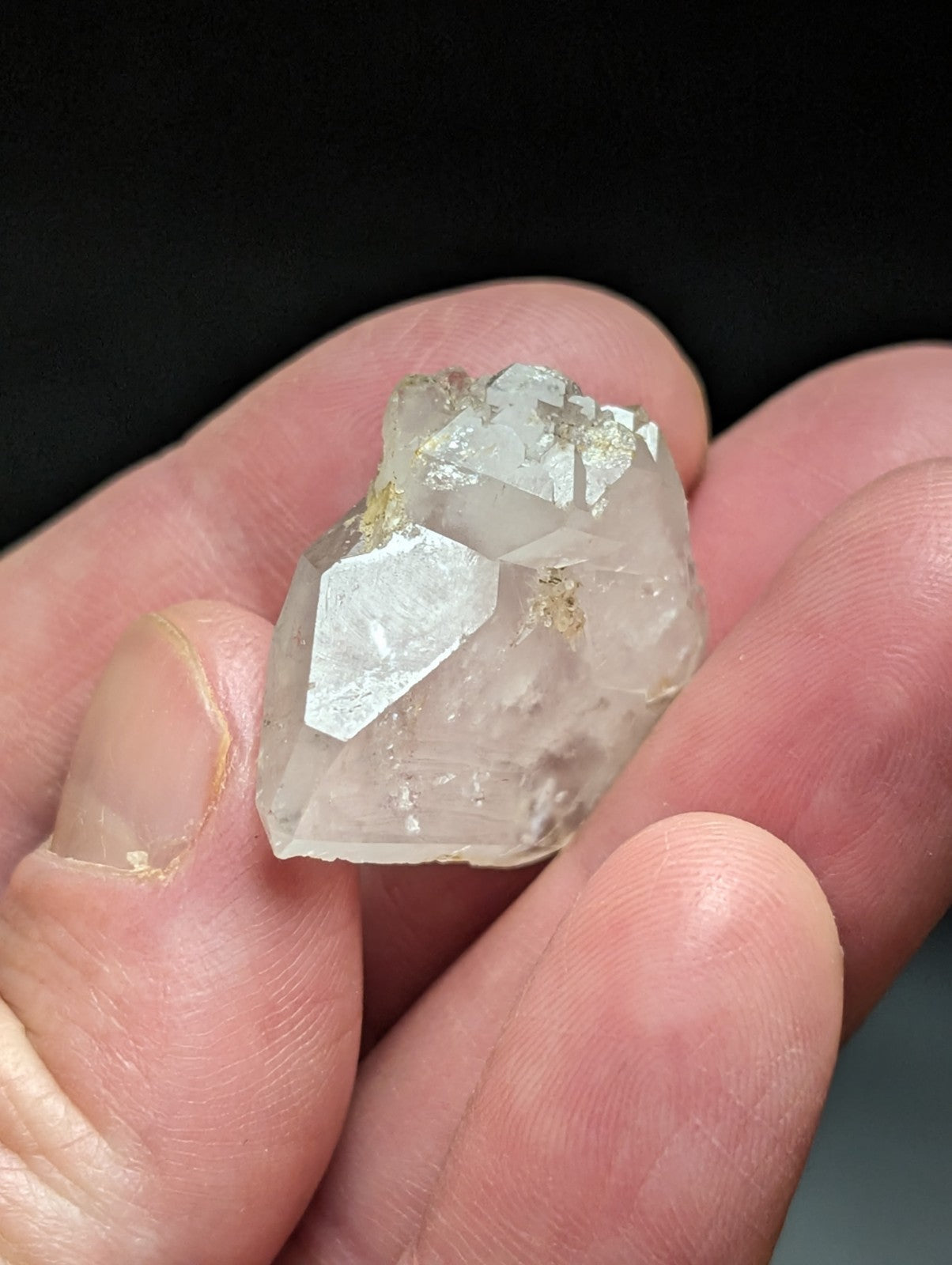A translucent, faceted quartz crystal with a pale, slightly cloudy appearance and subtle golden inclusions.