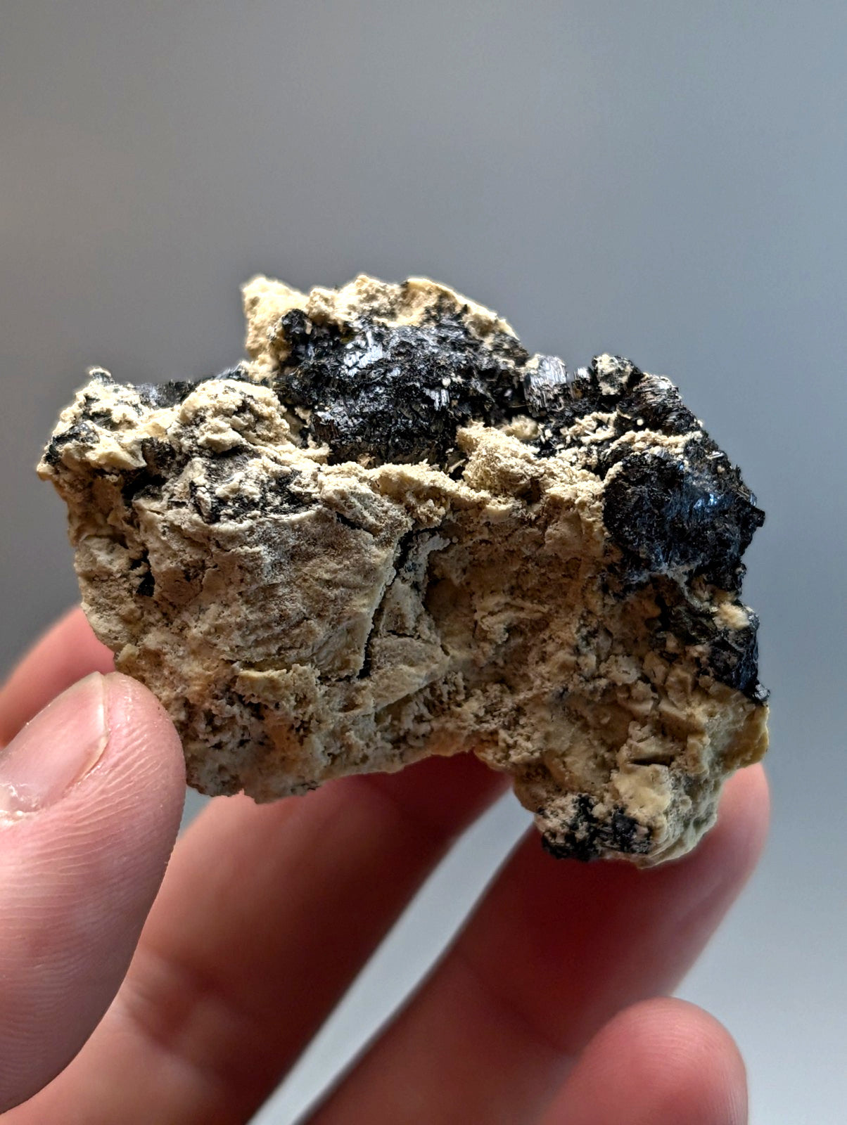 Rutile in matrix specimen from magnet cove arkansas with beige base and dark black rough mineral patches