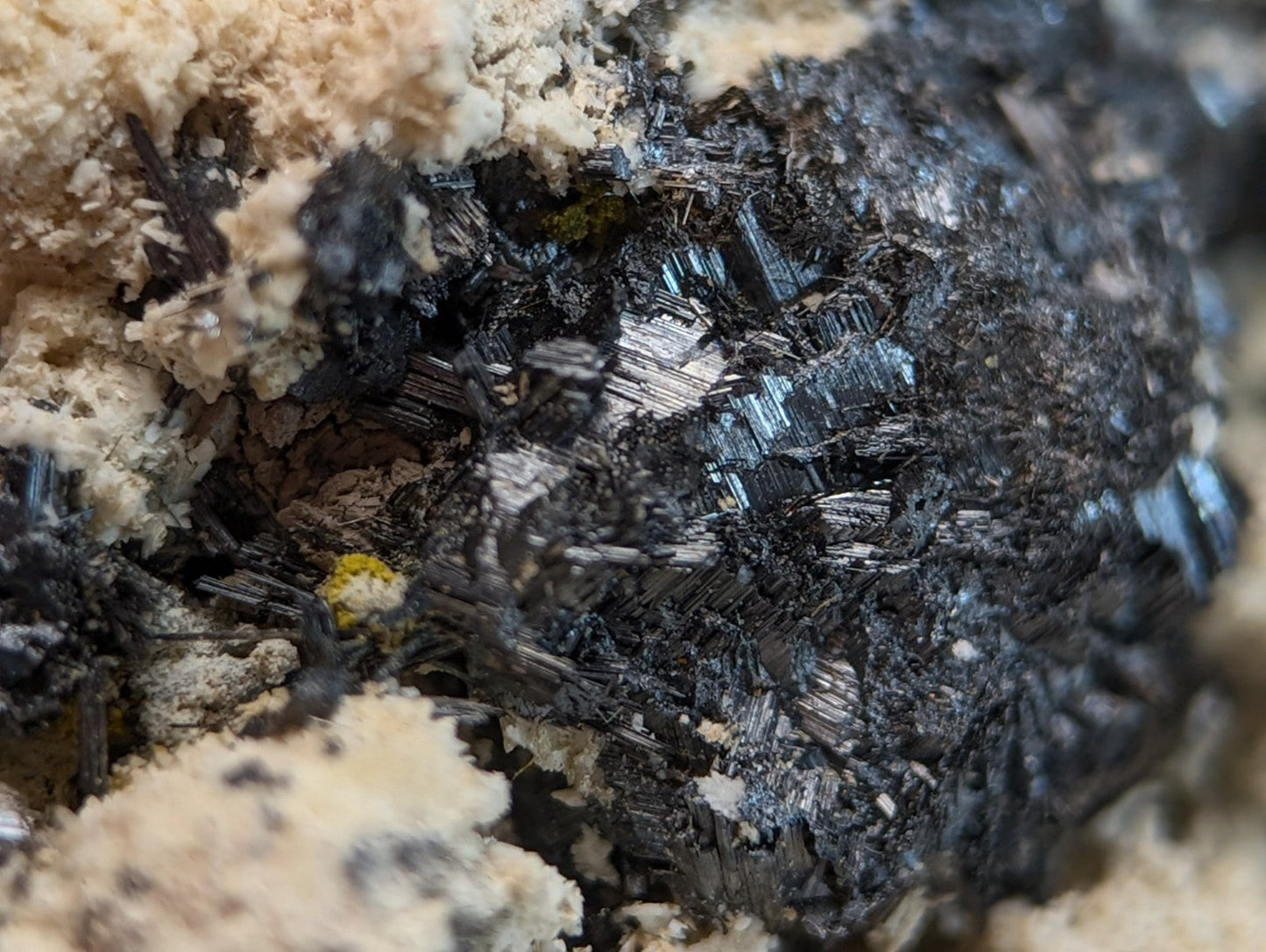 A cluster of dark metallic rutile crystals with sharp facets in beige matrix from magnet cove arkansas super rare