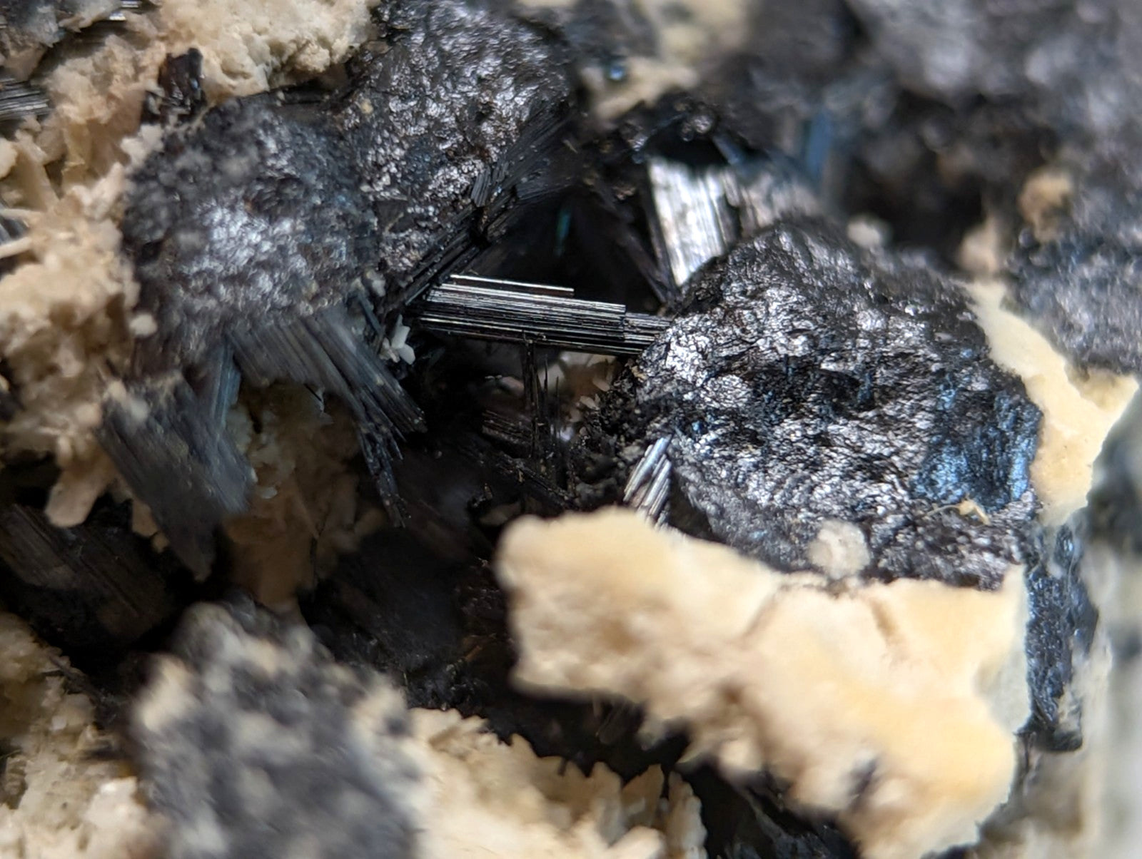 Black needle-like rutile crystals with metallic sheen in beige porous matrix from magnet cove arkansas beautiful cluster