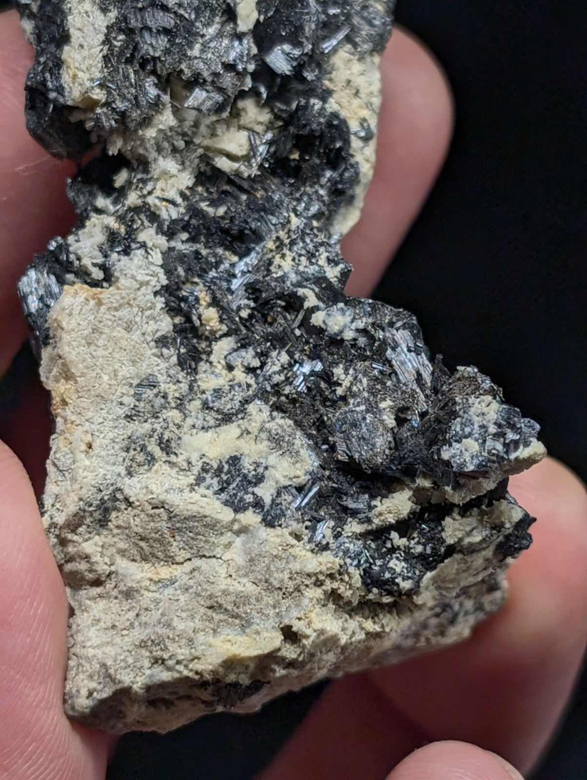A rugged, irregularly shaped mineral specimen featuring a striking contrast between dark, crystalline inclusions and lighter, earthy matrix material.