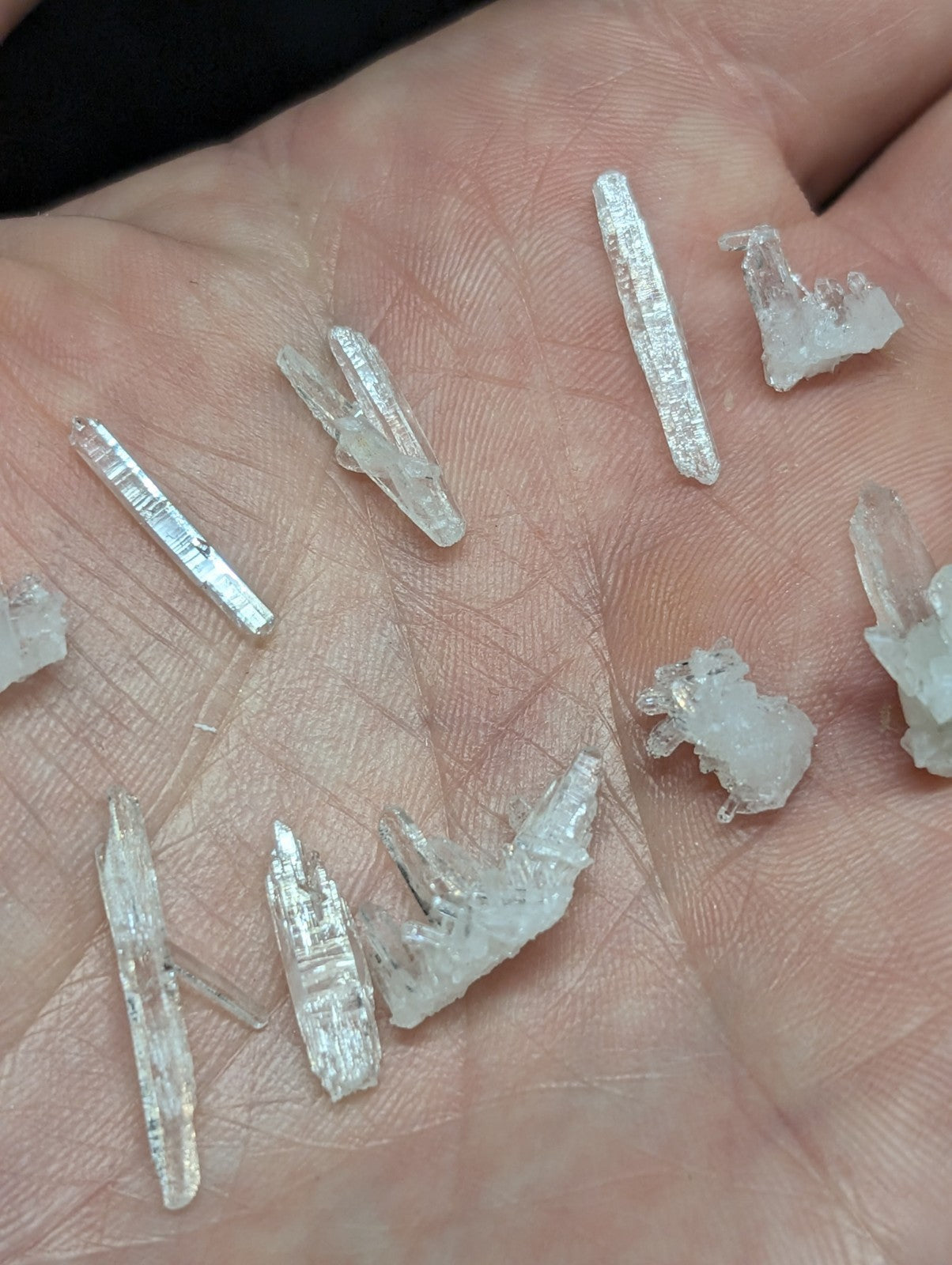 Clear quartz crystals of varying sizes and shapes, some with visible internal striations.