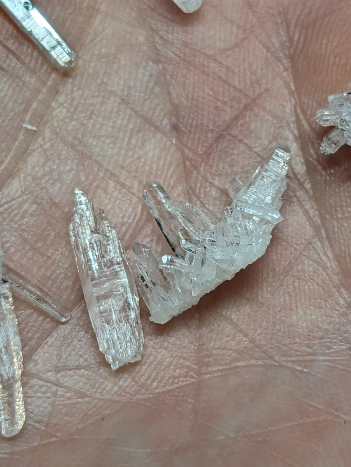 Clear, translucent quartz crystal clusters with jagged edges and layered internal striations.