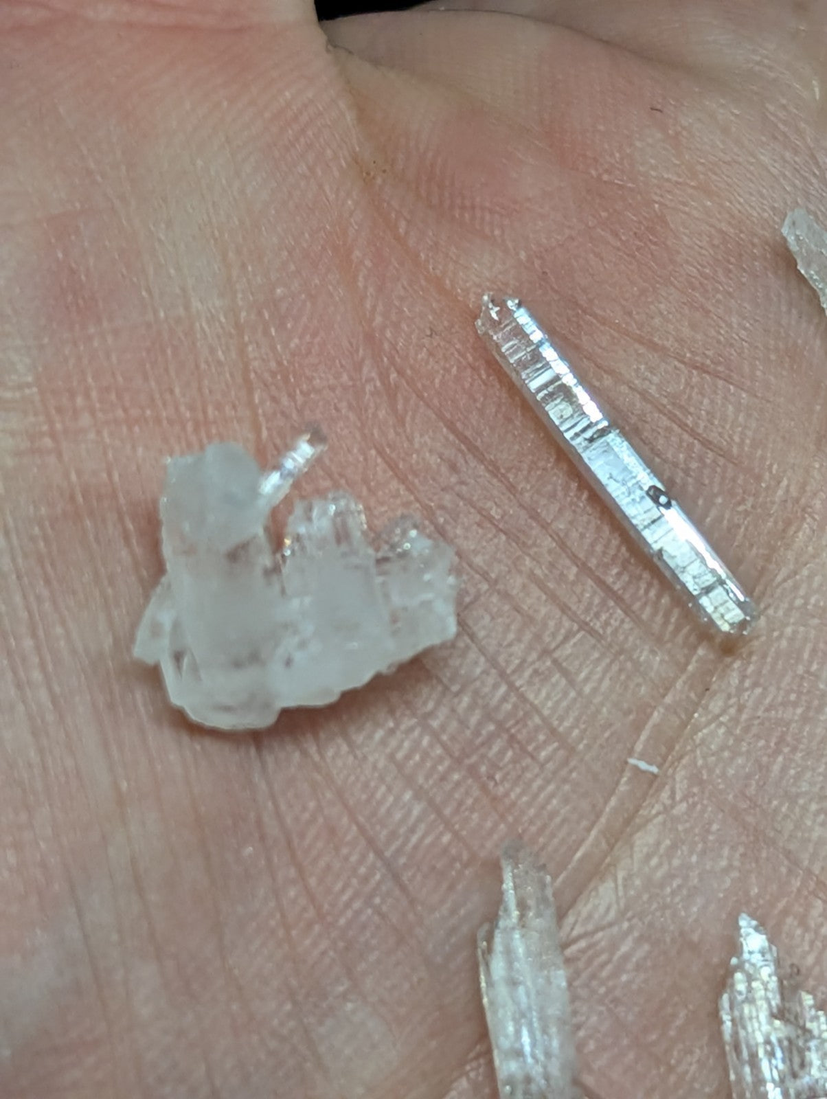 A translucent, crystalline mineral specimen with a jagged, irregular shape and a metallic sheen.