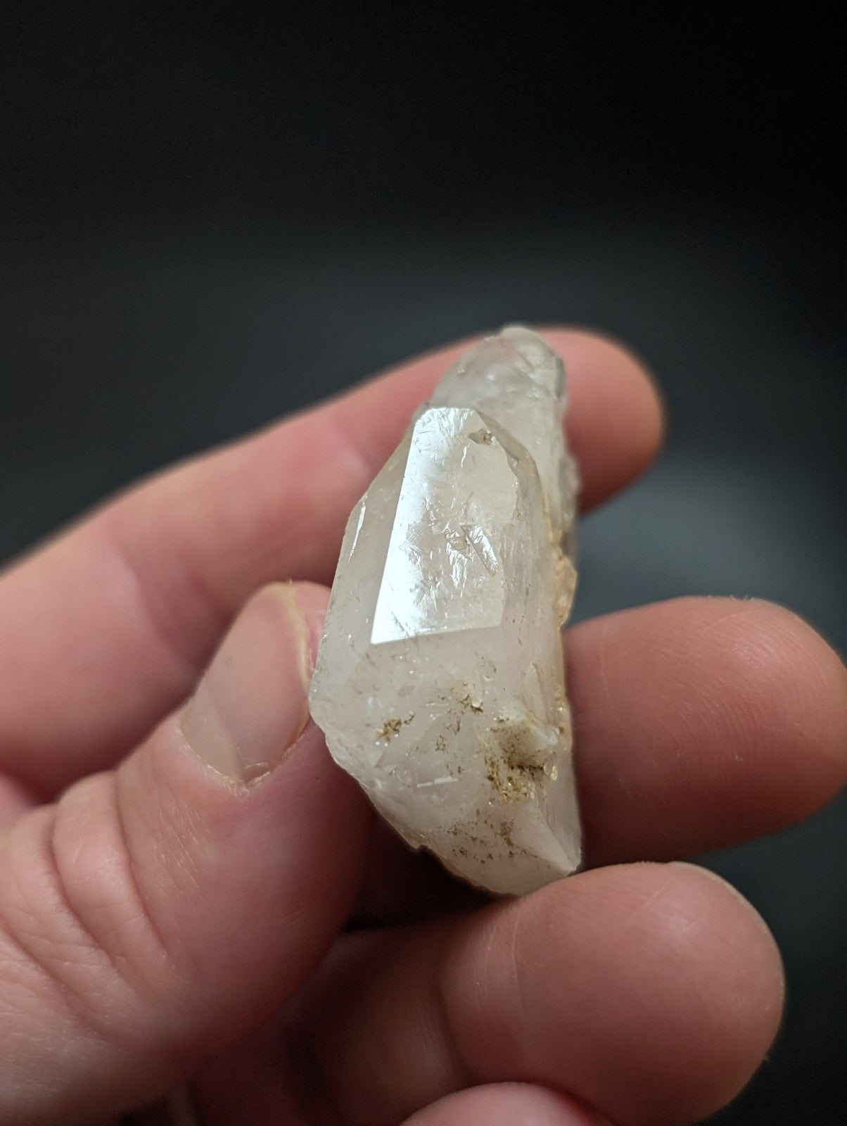 A translucent, pale quartz crystal with a pointed tip and natural facets.