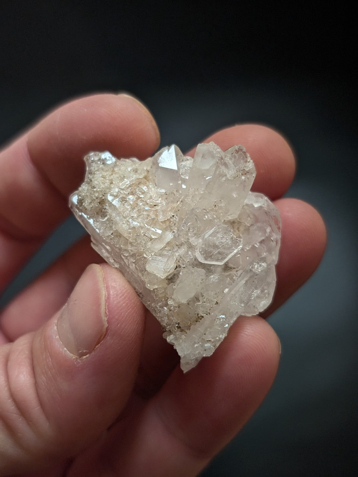A translucent, crystalline quartz cluster with sharp facets and a pale, glassy sheen.