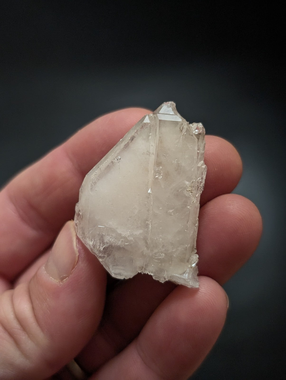 A translucent, clear quartz crystal with a rough, jagged surface and visible internal inclusions.