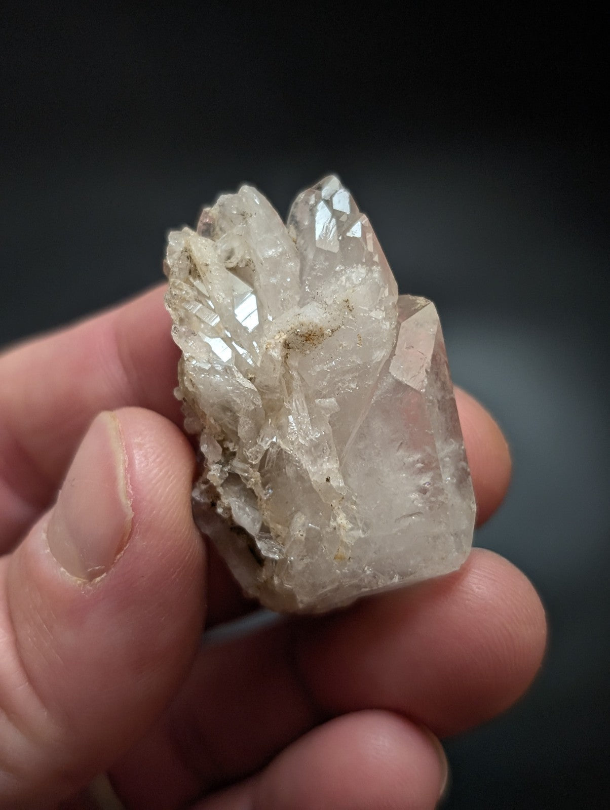 A translucent, clear quartz crystal cluster with sharp facets and a slightly cloudy base.