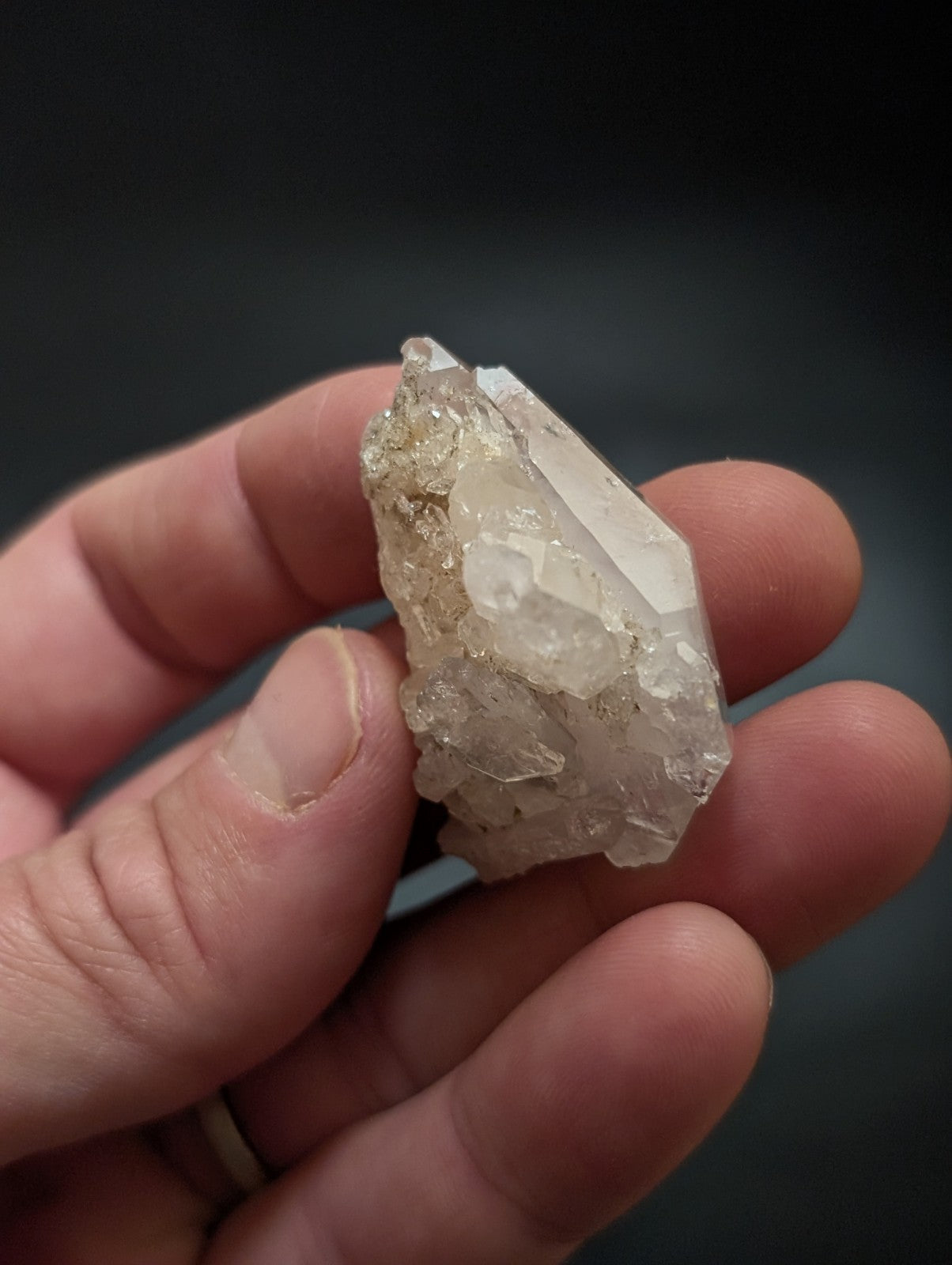 A translucent, pale quartz crystal cluster with a rough, faceted surface and subtle internal inclusions.