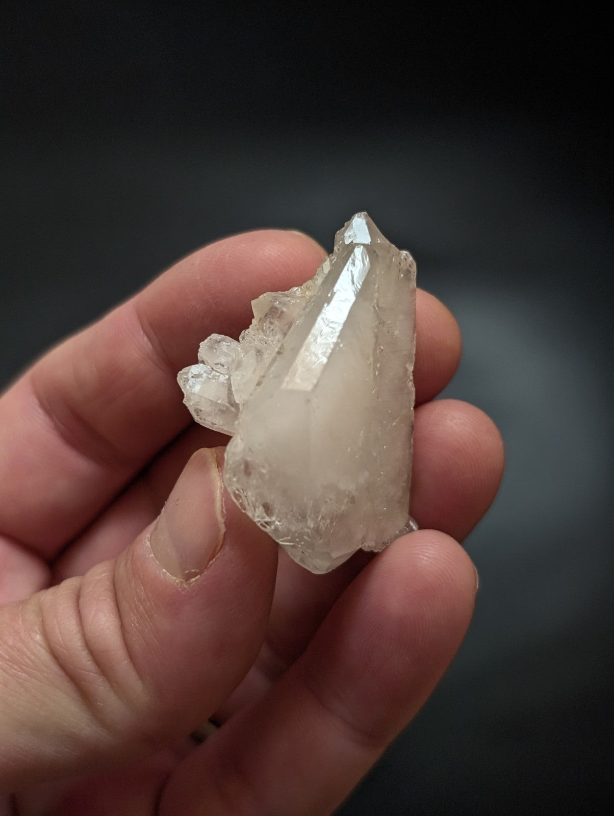 A translucent, pale quartz crystal cluster with sharp facets and a natural, rough-edged form.