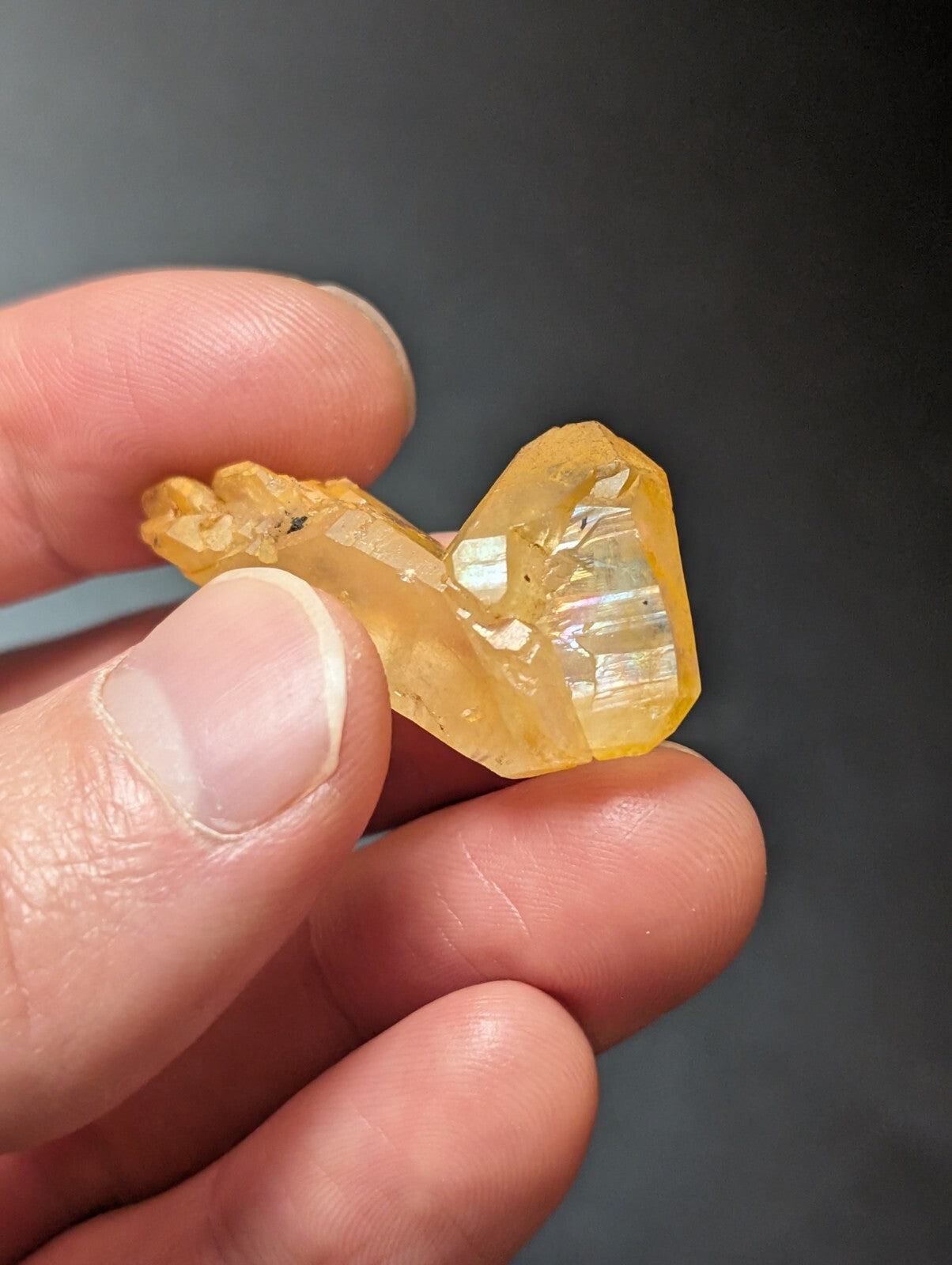 A translucent yellow crystal with a faceted, geometric shape and visible internal striations.