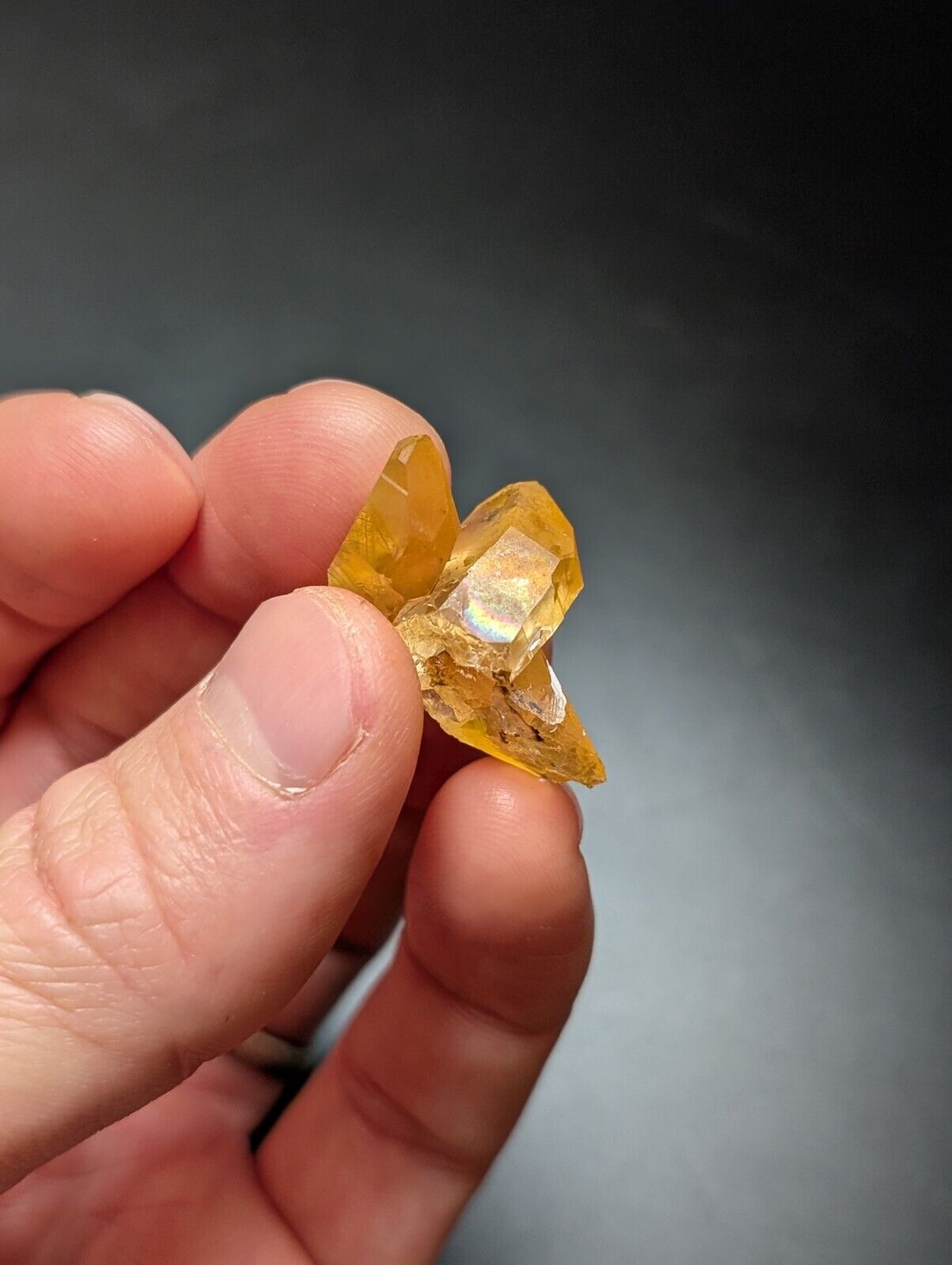 Hand holding a yellow crystal.
