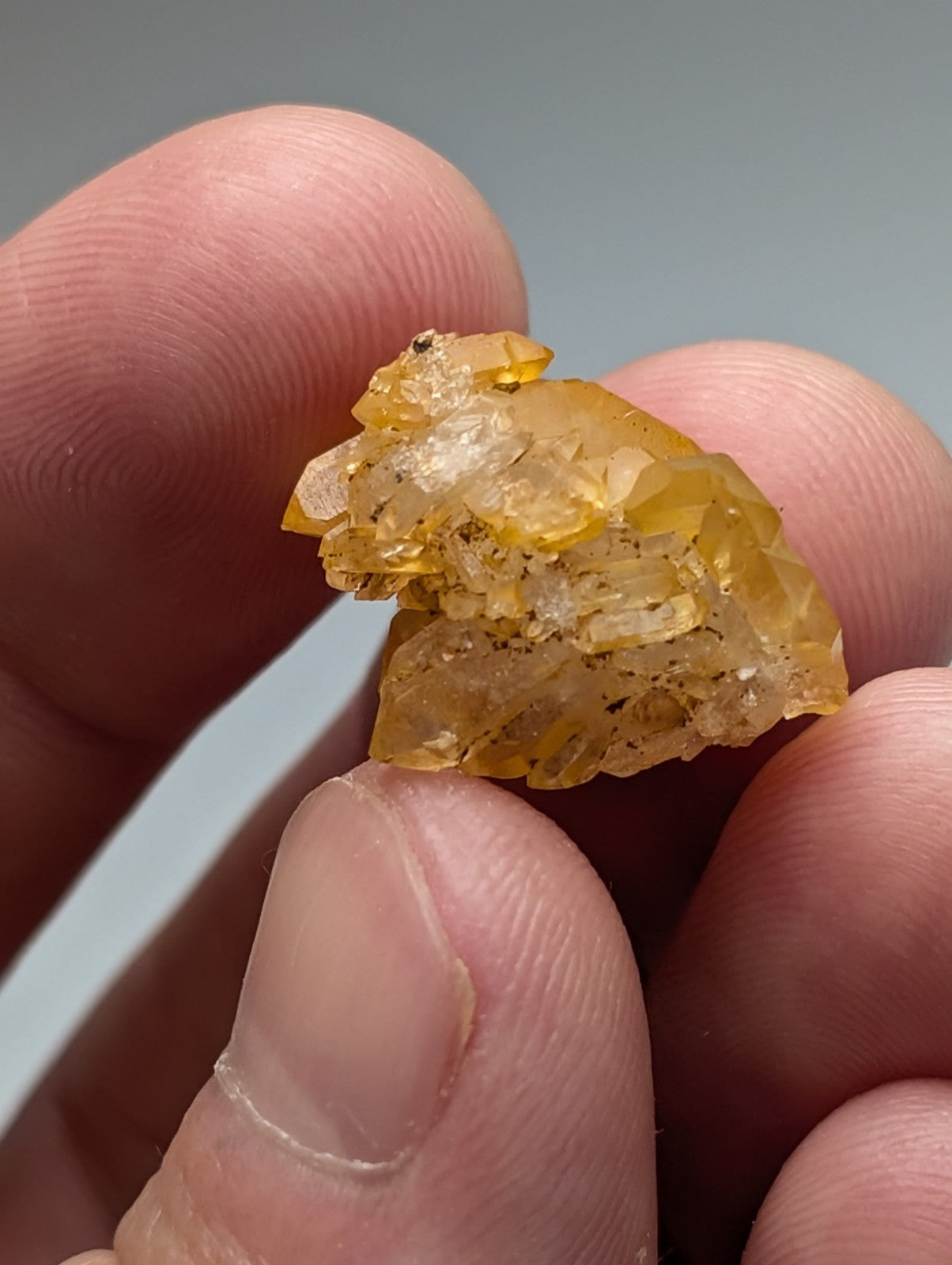 A translucent golden-yellow Arkansas quartz crystal cluster with sharp edges and natural iridescence in a set of 3