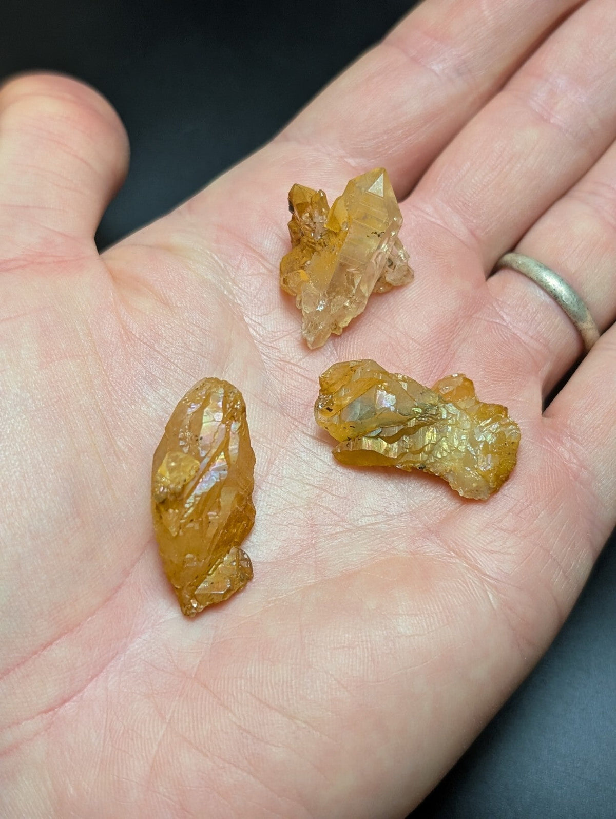 Golden-yellow citrine crystal clusters resting in an open palm.