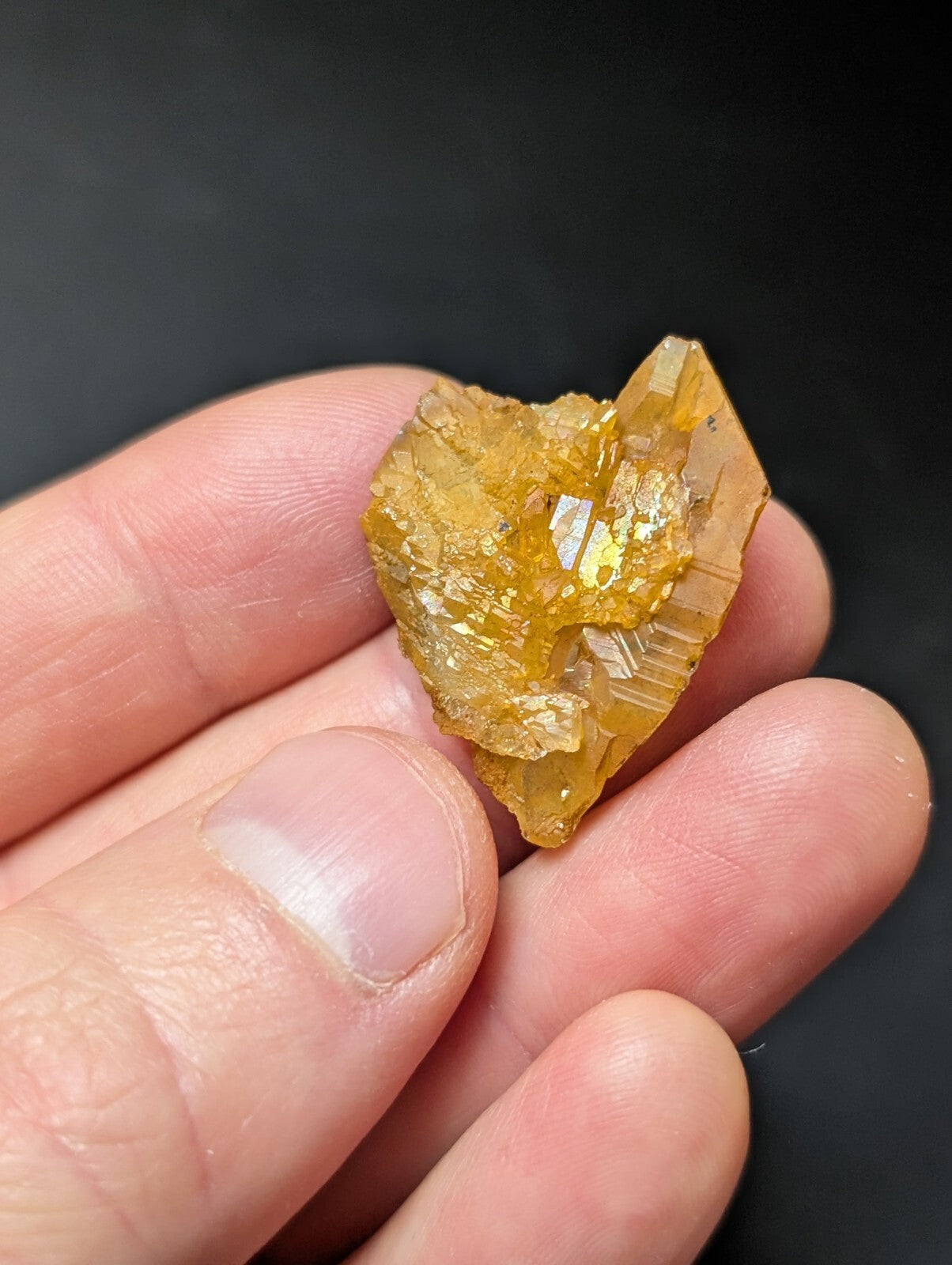 A translucent golden-yellow crystal with a rough, jagged surface and visible internal striations.