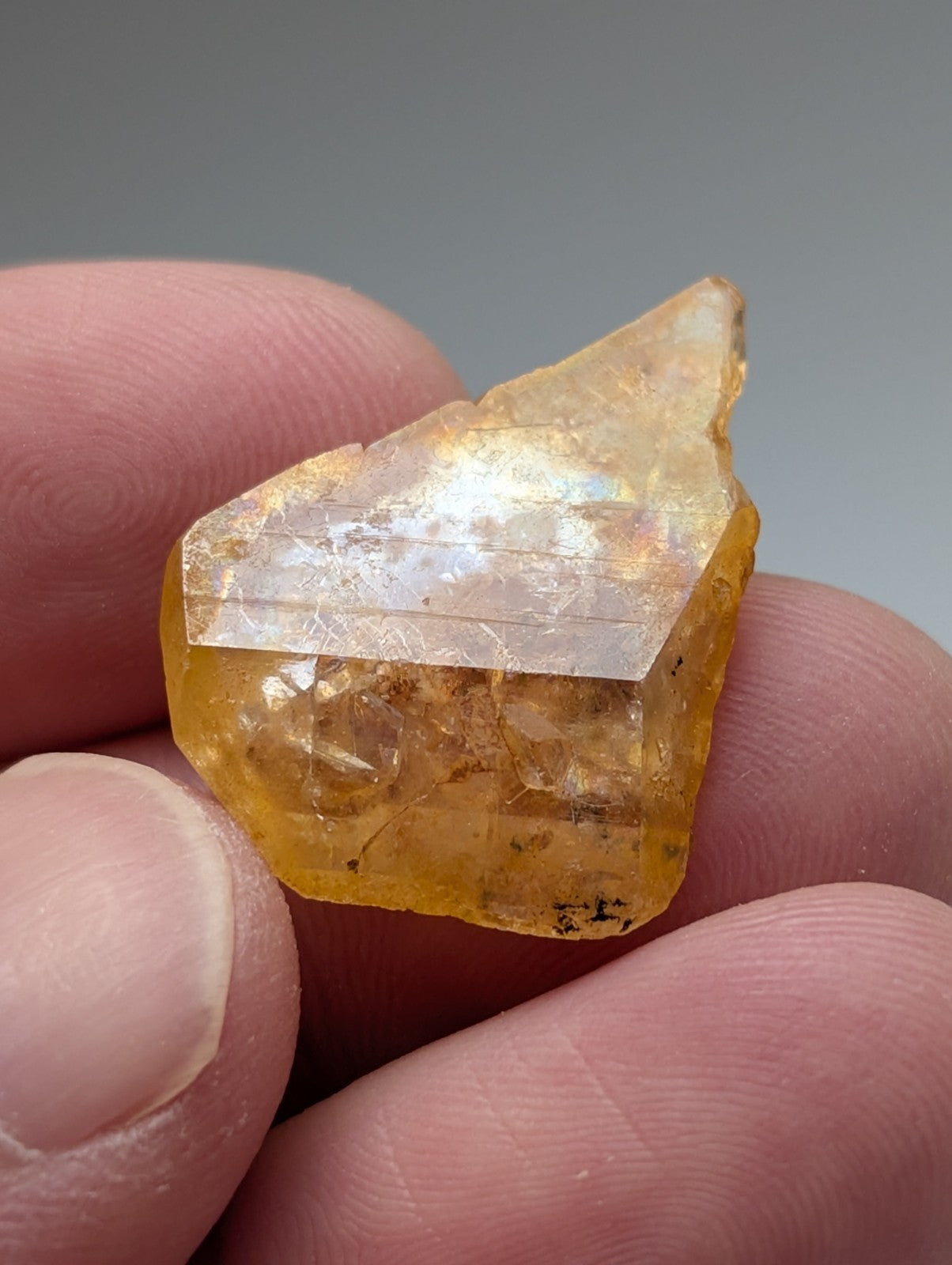 A translucent yellow-orange Arkansas quartz crystal with faceted shape and natural iridescence unique and OOAK