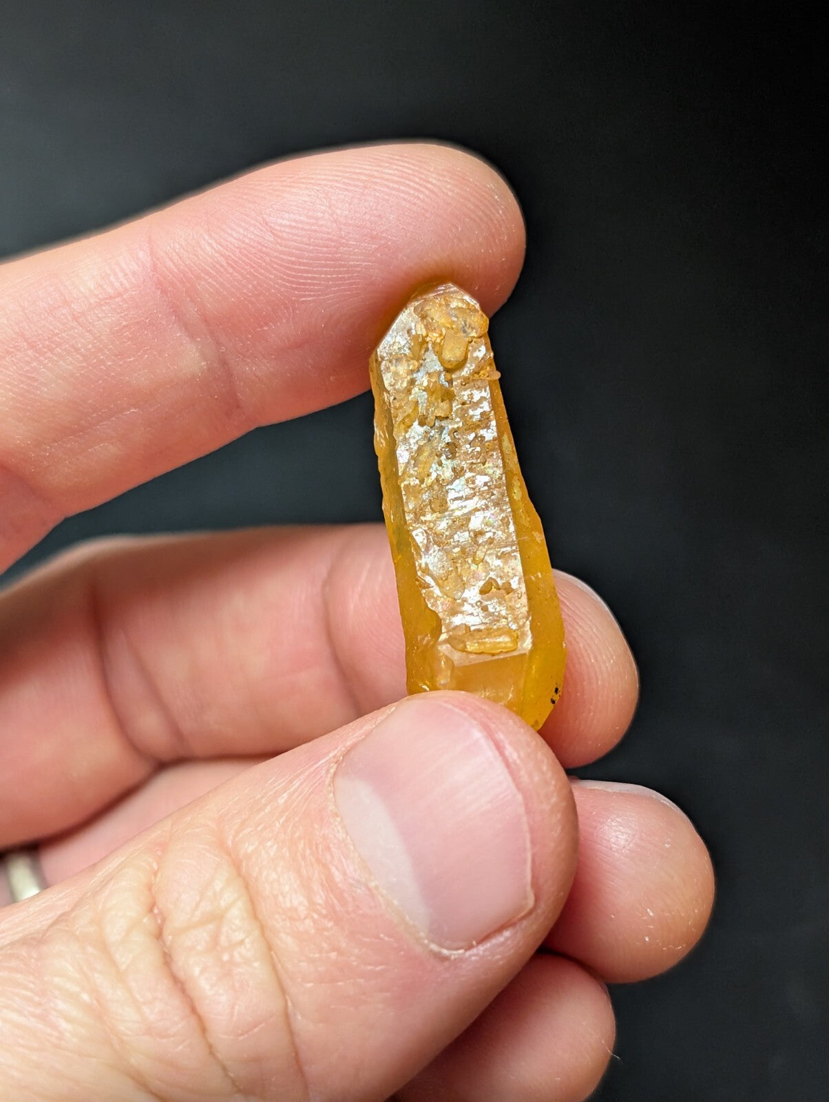 A translucent amber-colored crystal with a rough, natural surface and visible internal inclusions.