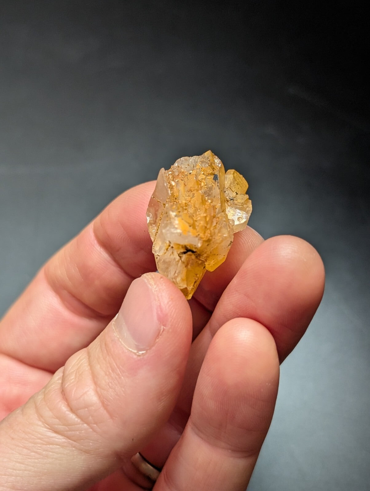 A translucent yellow-orange crystal with a rough, jagged surface and visible internal inclusions.