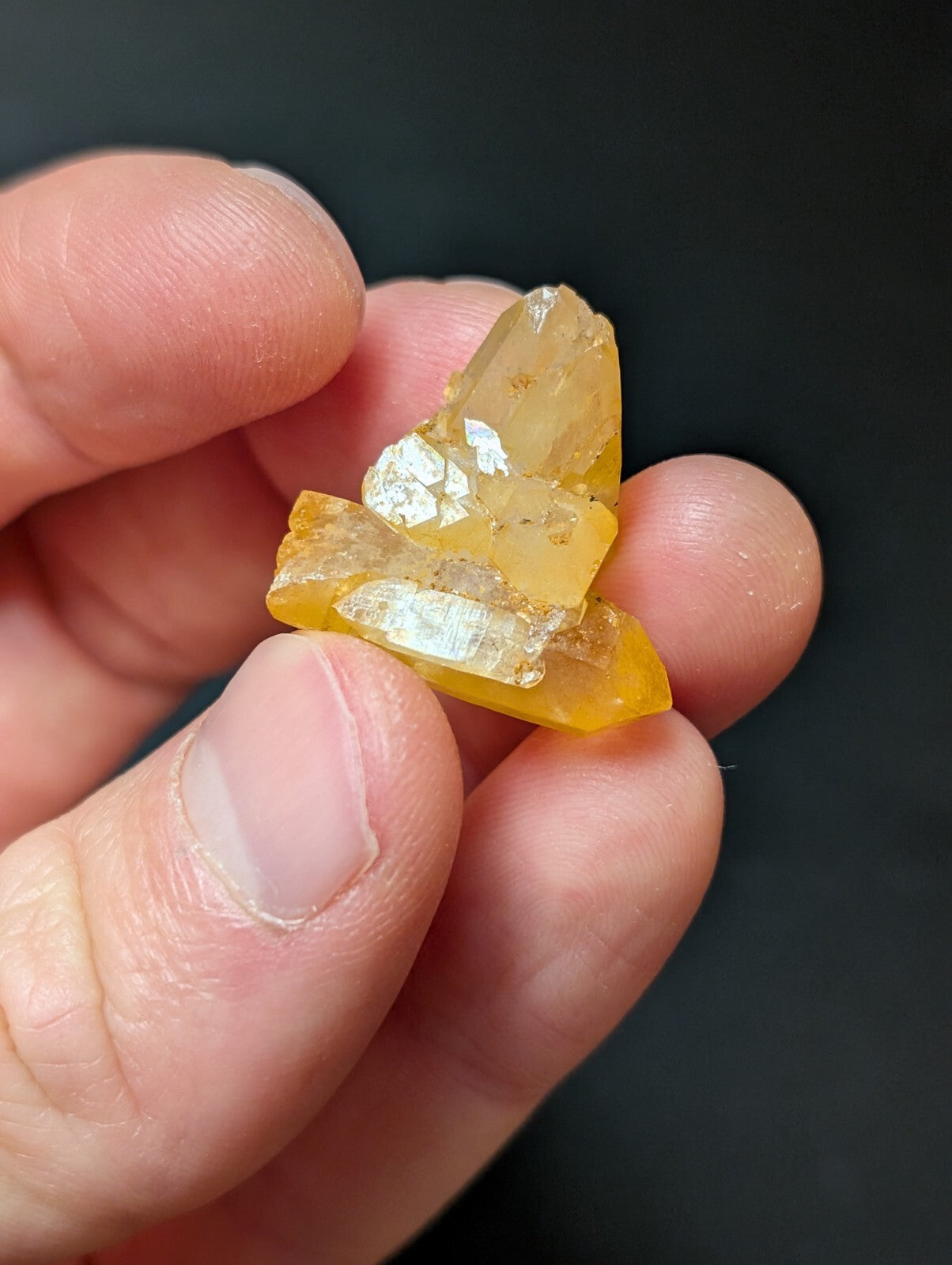 A translucent amber-colored crystal cluster with sharp, faceted edges and a slightly cloudy interior.