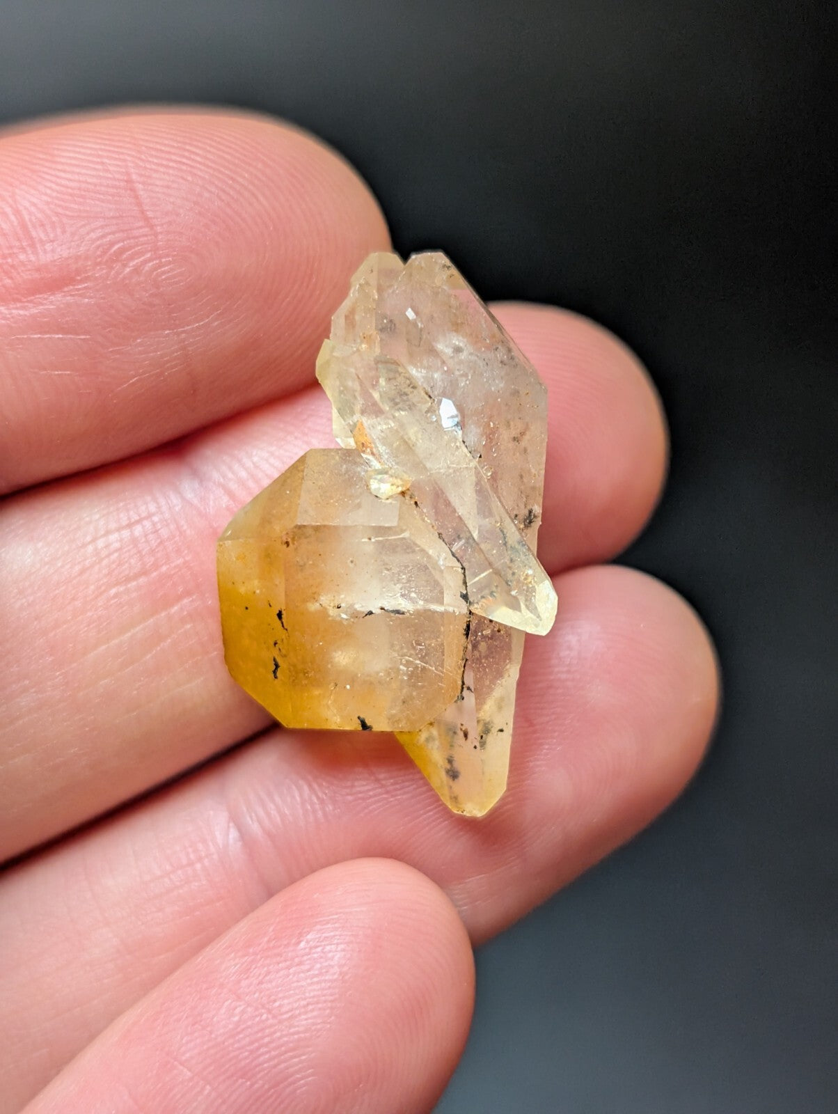 A translucent yellow-orange crystal cluster with sharp, faceted edges and natural inclusions.