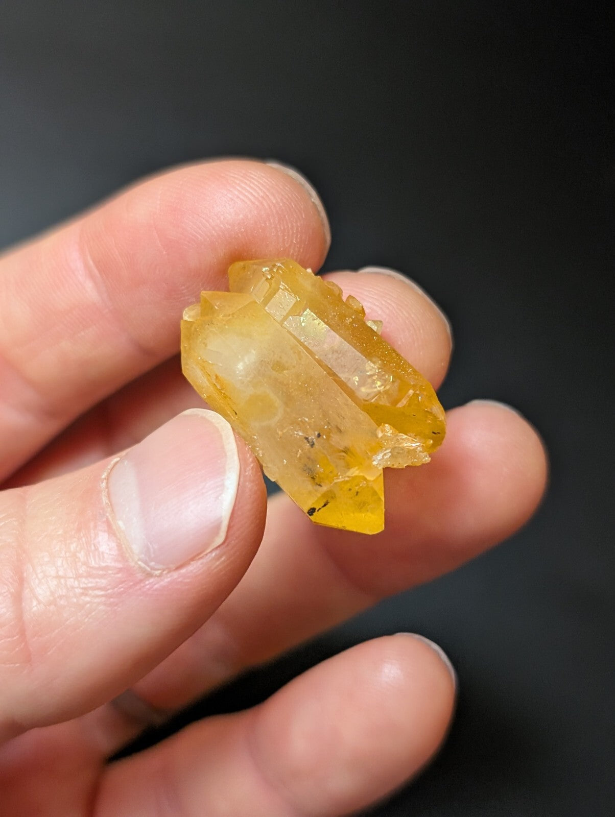 A translucent yellow crystal with a faceted, natural geometric shape.