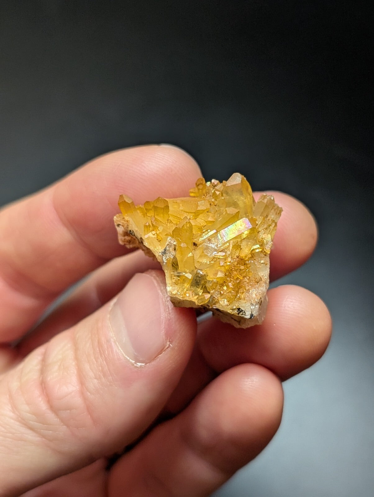 A cluster of translucent golden-yellow crystals with a crystalline, faceted structure and subtle iridescent highlights.