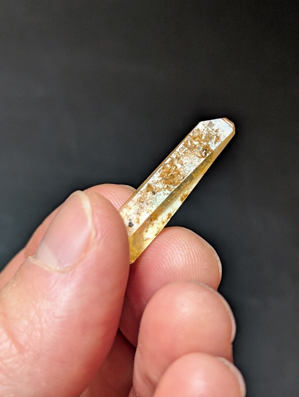 Yellowish crystal point with inclusions.