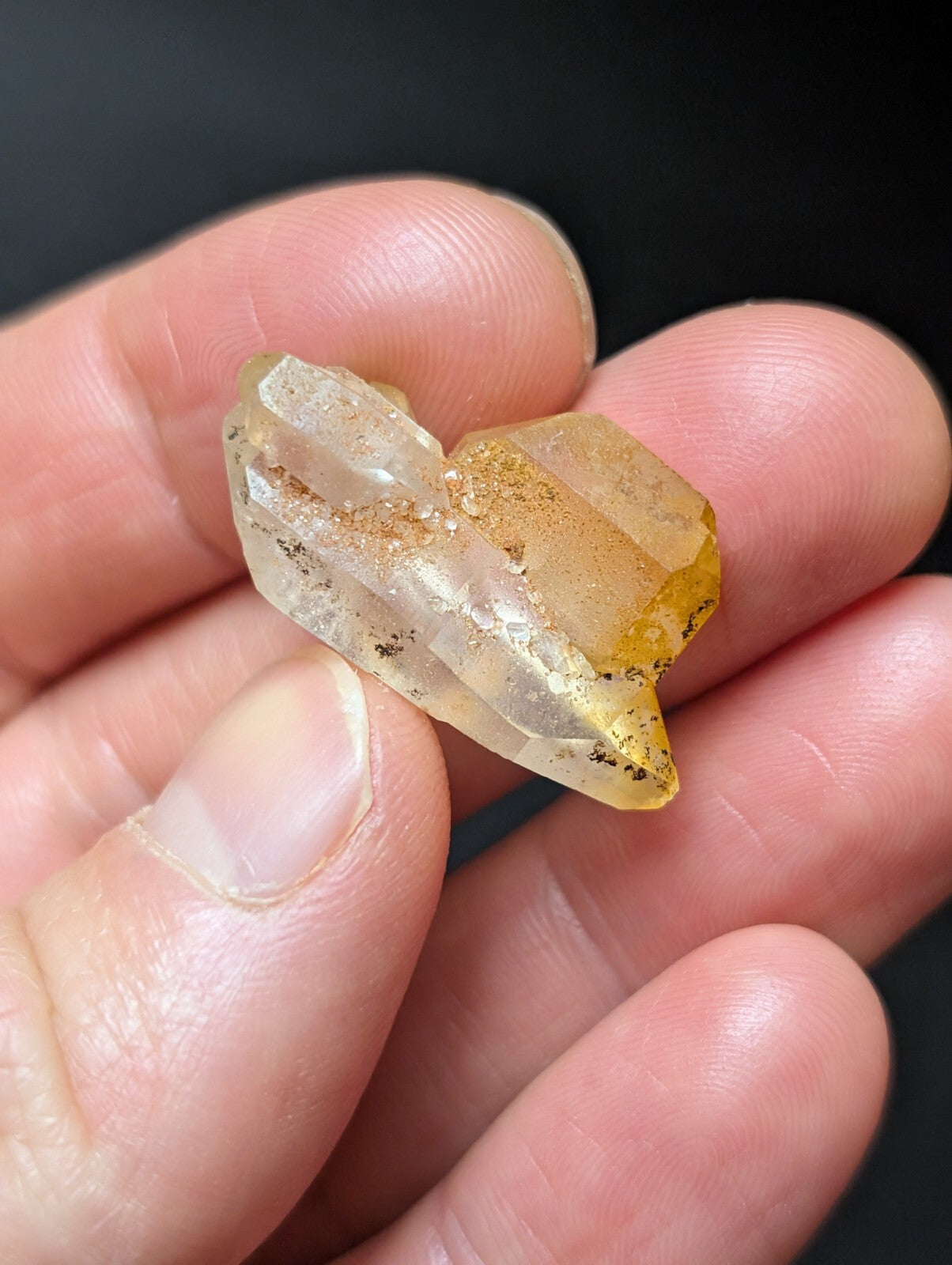 A translucent yellowish crystal with a faceted, geometric shape and visible internal inclusions.