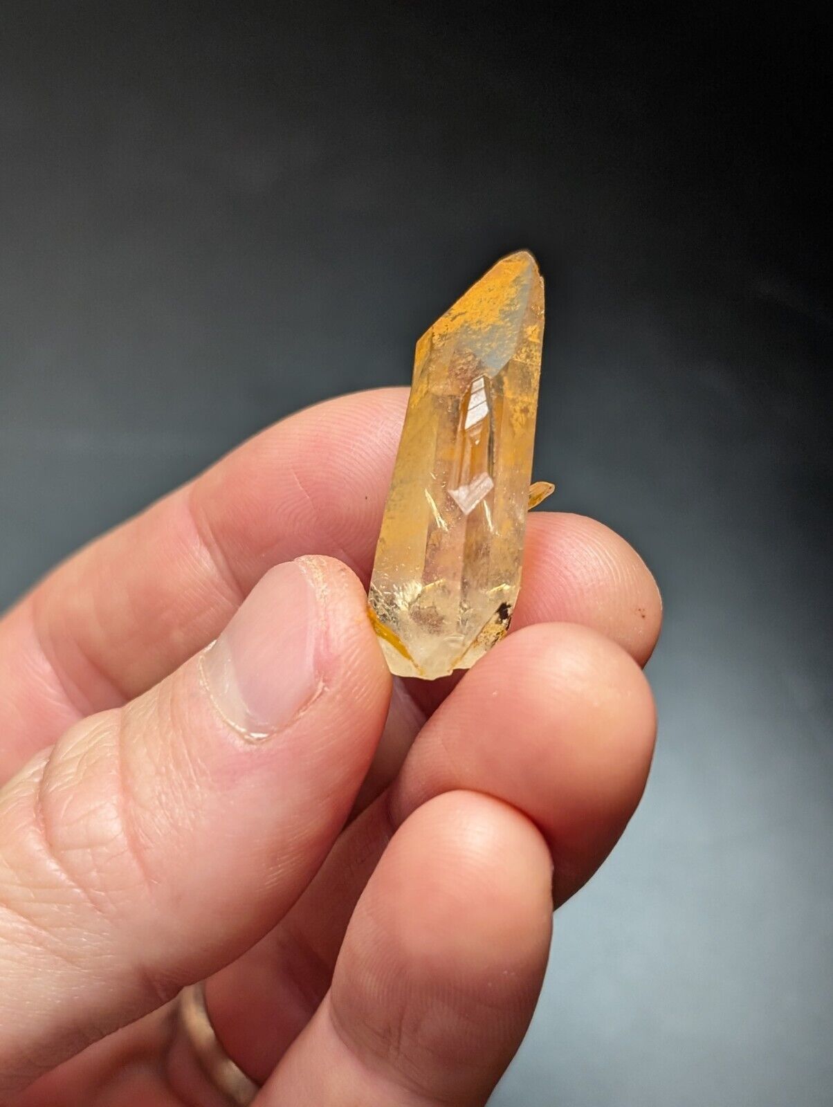 Golden-hued quartz crystal point.