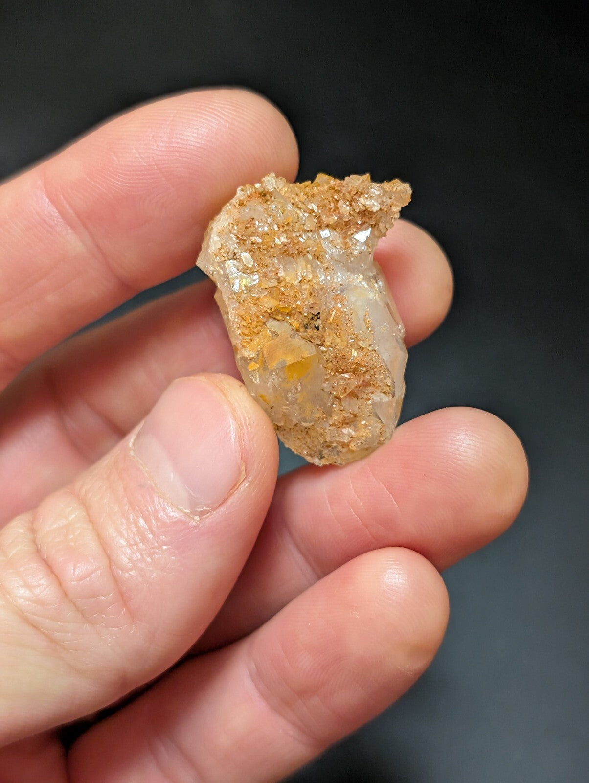 A translucent, irregularly shaped crystal specimen with golden-brown mineral inclusions and a rough, natural surface.