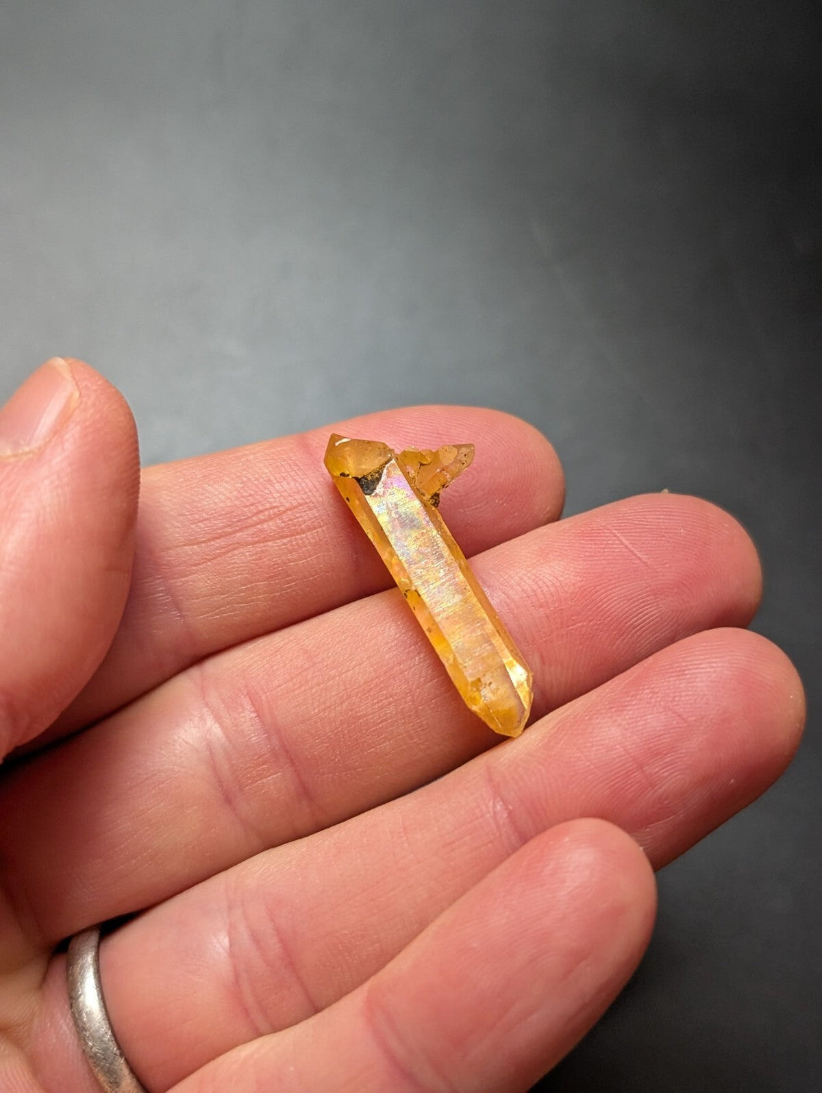 A translucent golden-yellow citrine crystal with a pointed, faceted tip and natural imperfections.