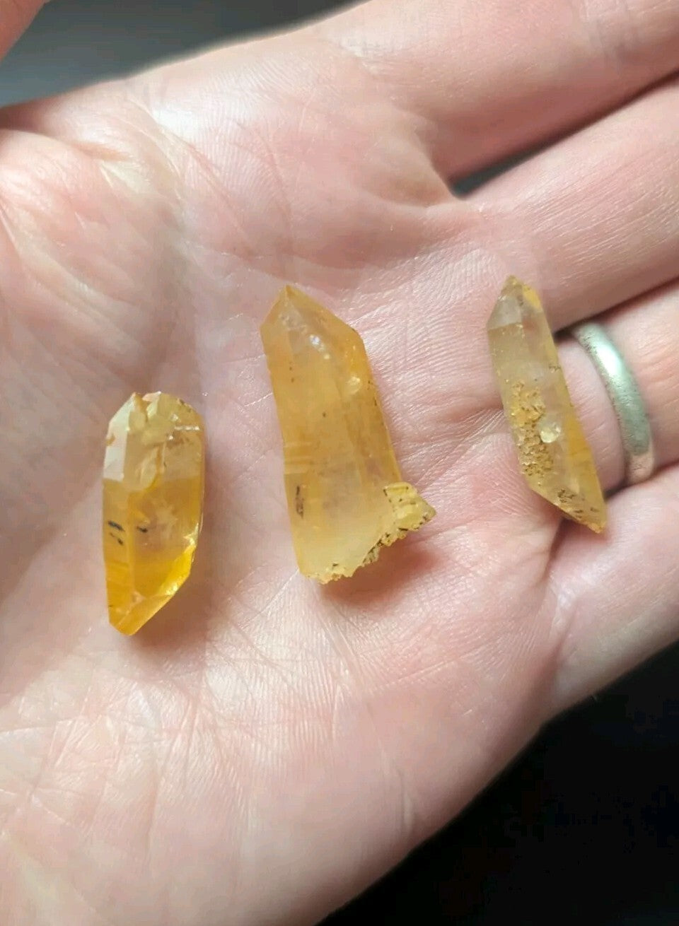 Three translucent yellow crystal points with natural inclusions and rough, jagged edges.