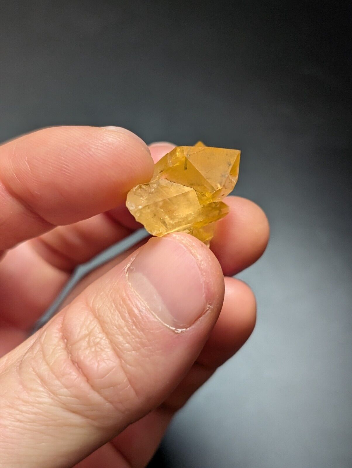 Hand holding a yellow crystal.