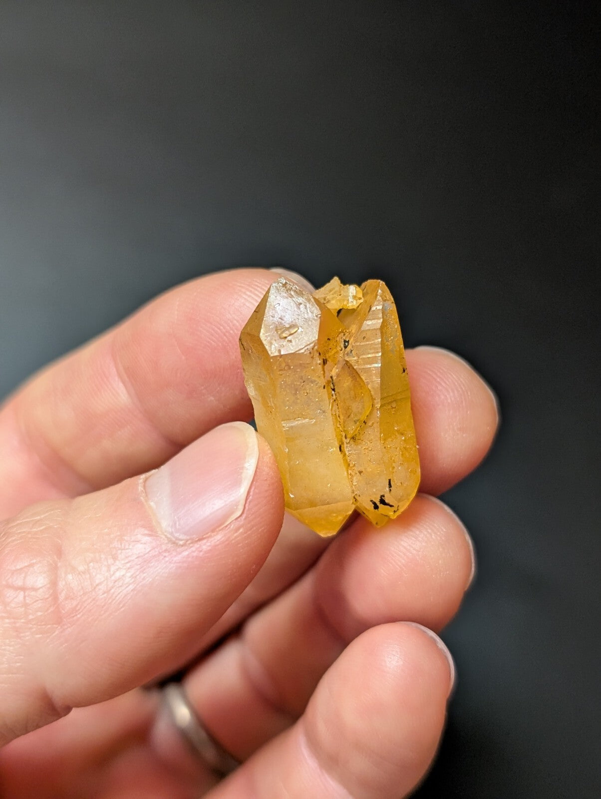 A translucent golden-yellow quartz crystal cluster with a faceted, pointed structure and subtle internal inclusions.