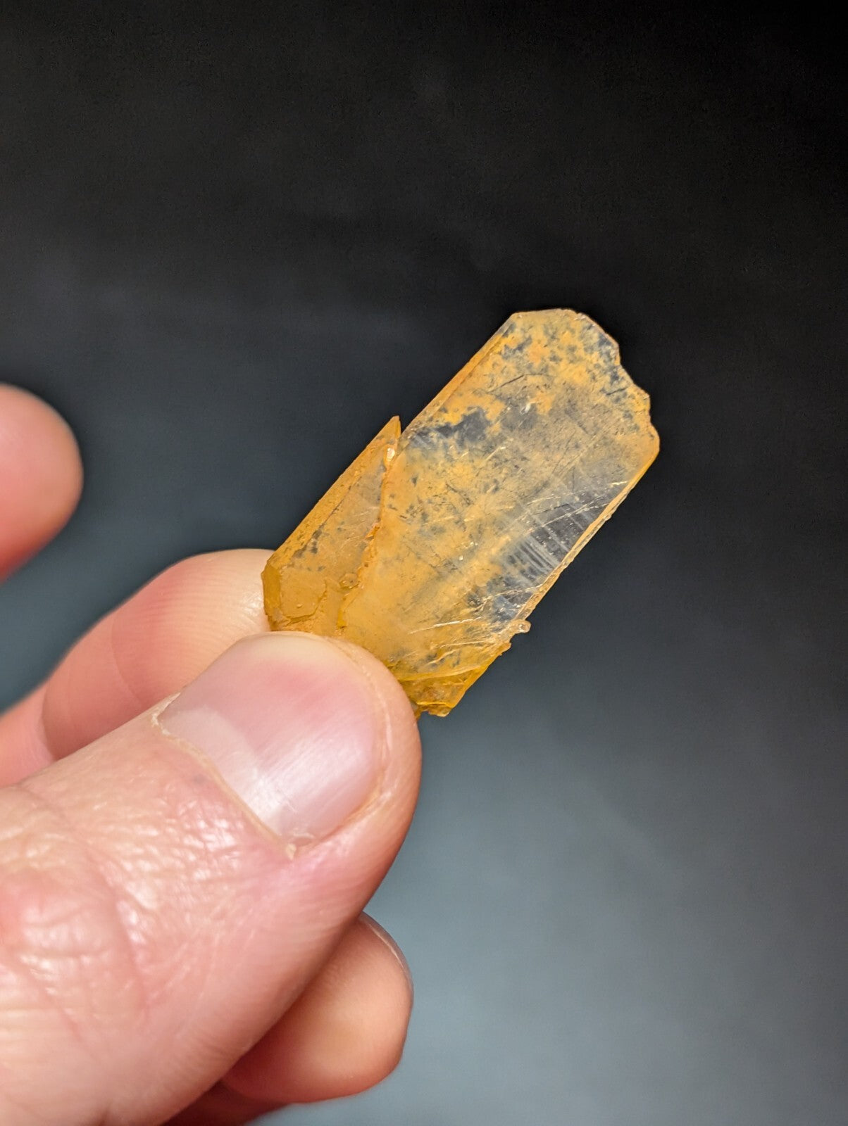 A translucent yellow crystal with a faceted, elongated shape and visible internal inclusions.