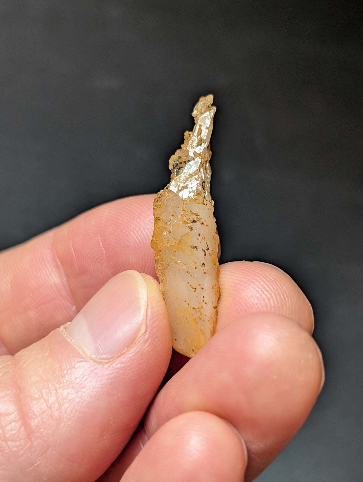 A translucent, amber-hued piece of ancient stone with a rough, jagged edge and subtle internal veining.