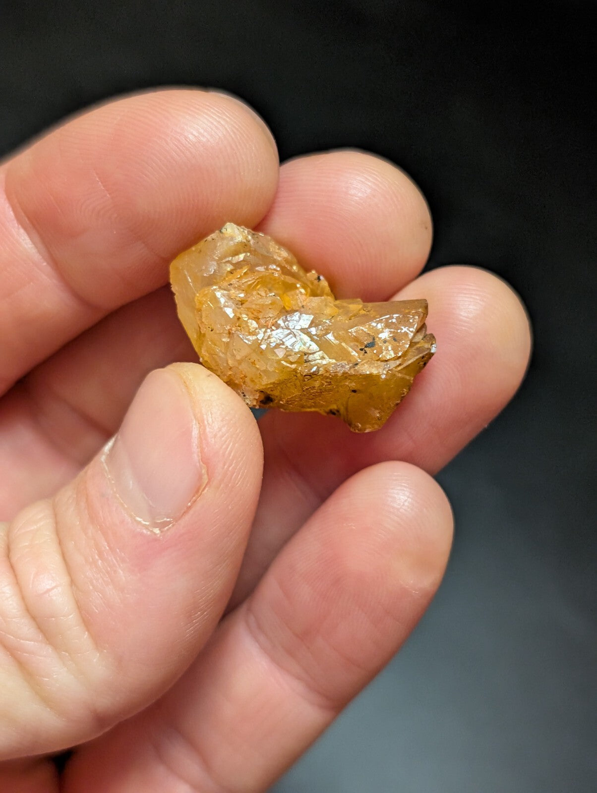 A translucent amber-colored, irregularly shaped mineral specimen with visible internal crystalline structures.